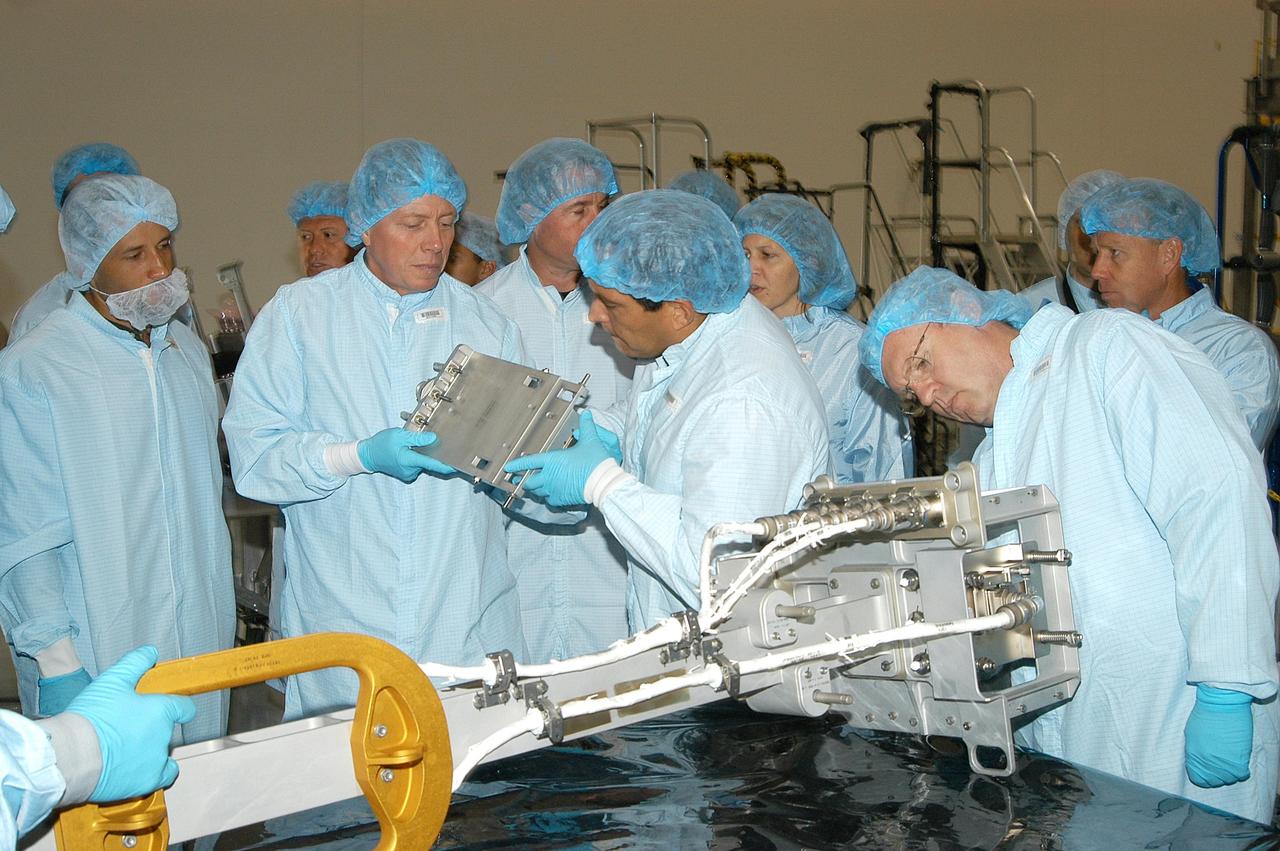 KENNEDY SPACE CENTER, FLA. - In the Space Station Processing Facility, members of several Space Shuttle mission crews get a close look at the Video Stanchion Support Assembly (VSSA) that will fly on STS-114 (Logistics Flight 1).  Holding one piece at left are STS-116 Mission Specialist Christer Fuglesang (European Space Agency) and STS-121 Mission Specialist Carlos Noriega.  Looking at the VSSA on the table is STS-114 Mission Specialist Andrew Thomas.  The crews are at KSC for equipment familiarization.