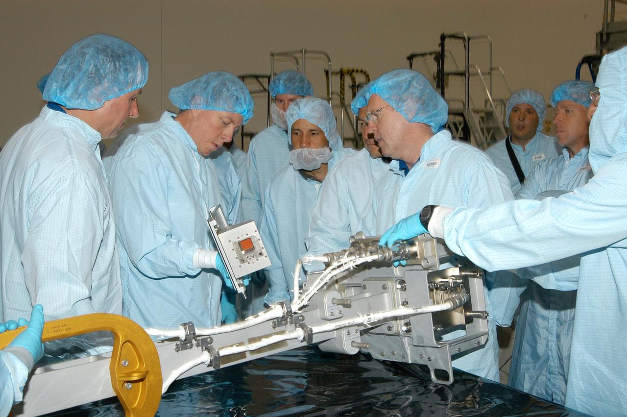 KENNEDY SPACE CENTER, FLA. - In the Space Station Processing Facility, members of several Space Shuttle mission crews get a close look at the Video Stanchion Support Assembly (VSSA) that will fly on STS-114 (Logistics Flight 1).   On the left are STS-114 Mission Specialist Stephen Robinson and STS-116 Mission Specialist Christer Fuglesang (European Space Agency).  Center right is STS-114 Mission Specialist Andrew Thomas. The crews are at KSC for equipment familiarization.