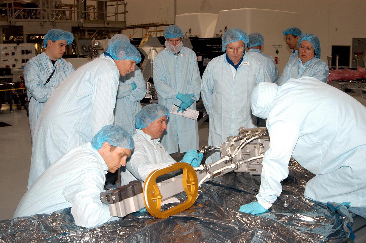 KENNEDY SPACE CENTER, FLA. - In the Space Station Processing Facility, members of several Space Shuttle mission crews get a close look at the Video Stanchion Support Assembly (VSSA) that will fly on STS-114 (Logistics Flight 1).   Closest to the VSSA, in front, are astronaut Michael Gerhnardt and STS-114 Mission Specialist Stephen Robinson.  Leaning over behind them is STS-116 Mission Specialist Christer Fuglesang (European Space Agency); right of center is STS-114 Mission Specialist Andrew Thomas. The crews are at KSC for equipment familiarization.