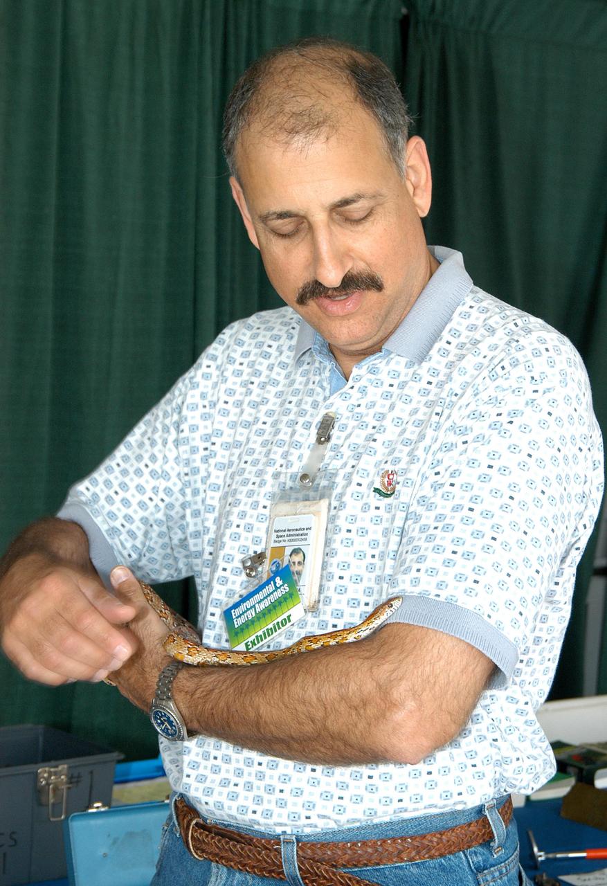 KENNEDY SPACE CENTER, FLA. - Mario Busacca, with the Safety, Occupational Health and Environmental Division, handles a snake at one of the exhibits for KSC’s annual Environmental and Energy Awareness Week, held April 20-22. Presentations included Chemistry Safety, Cost-Effective Solar Applications, Non-Native Invasive Plant Identification and Control, Energy Efficient Lighting Systems, and Historical Changes in KSC’s Ecosystems.  The slogan for this year’s event was “Today's Conservation Defines Tomorrow's Future.”