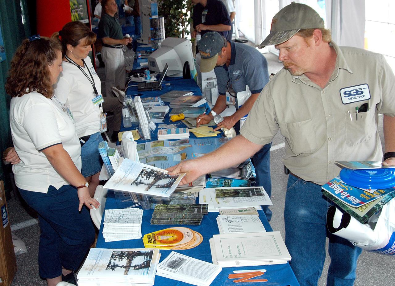 KENNEDY SPACE CENTER, FLA. - KSC employees stop at display tables set up in a tent near the Operations and Checkout Building for KSC’s annual Environmental and Energy Awareness Week, held April 20-22.  The slogan for this year’s event was “Today's Conservation Defines Tomorrow's Future.”  Presentations included Chemistry Safety, Cost-Effective Solar Applications, Non-Native Invasive Plant Identification and Control, Energy Efficient Lighting Systems, and Historical Changes in KSC’s Ecosystems.