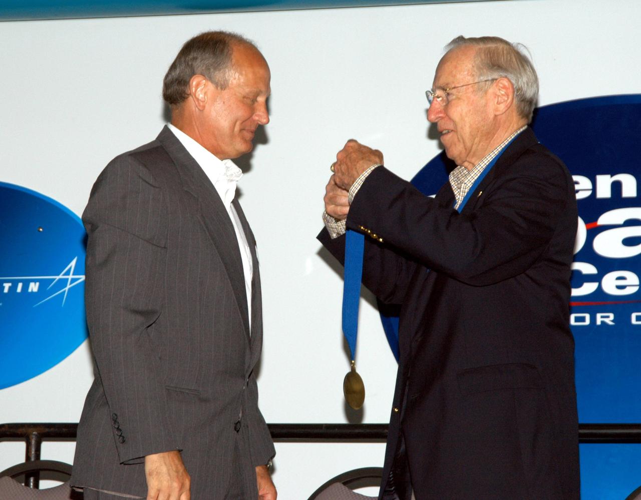 KENNEDY SPACE CENTER, FLA. -- At the Kennedy Space Center Visitor Complex, Dr. Norman E. Thagard (left) is ceremoniously inducted into the U.S. Astronaut Hall of Fame by former NASA astronaut James A. Lovell Jr. Thagard was the first American to occupy Russia's Mir space station. Also chosen for this honor in 2004 are Kathryn D. Sullivan, the first American woman to walk in space; Richard O. Covey, commander of the Hubble Space Telescope repair mission; Frederick D. Gregory, the first African-American to command a space mission; and the late Francis R. "Dick" Scobee, commander of the ill-fated 1986 Challenger mission. The U.S. Astronaut Hall of Fame opened in 1990 to provide a place where space travelers could be remembered for their participation and accomplishments in the U.S. space program. To be eligible for induction, an individual must have been a U.S. citizen, a NASA astronaut, and out of the active astronaut corps at least five years. The five inductees join 52 previously honored astronauts from the ranks of the Gemini, Apollo, Skylab, Apollo-Soyuz, and Space Shuttle programs.