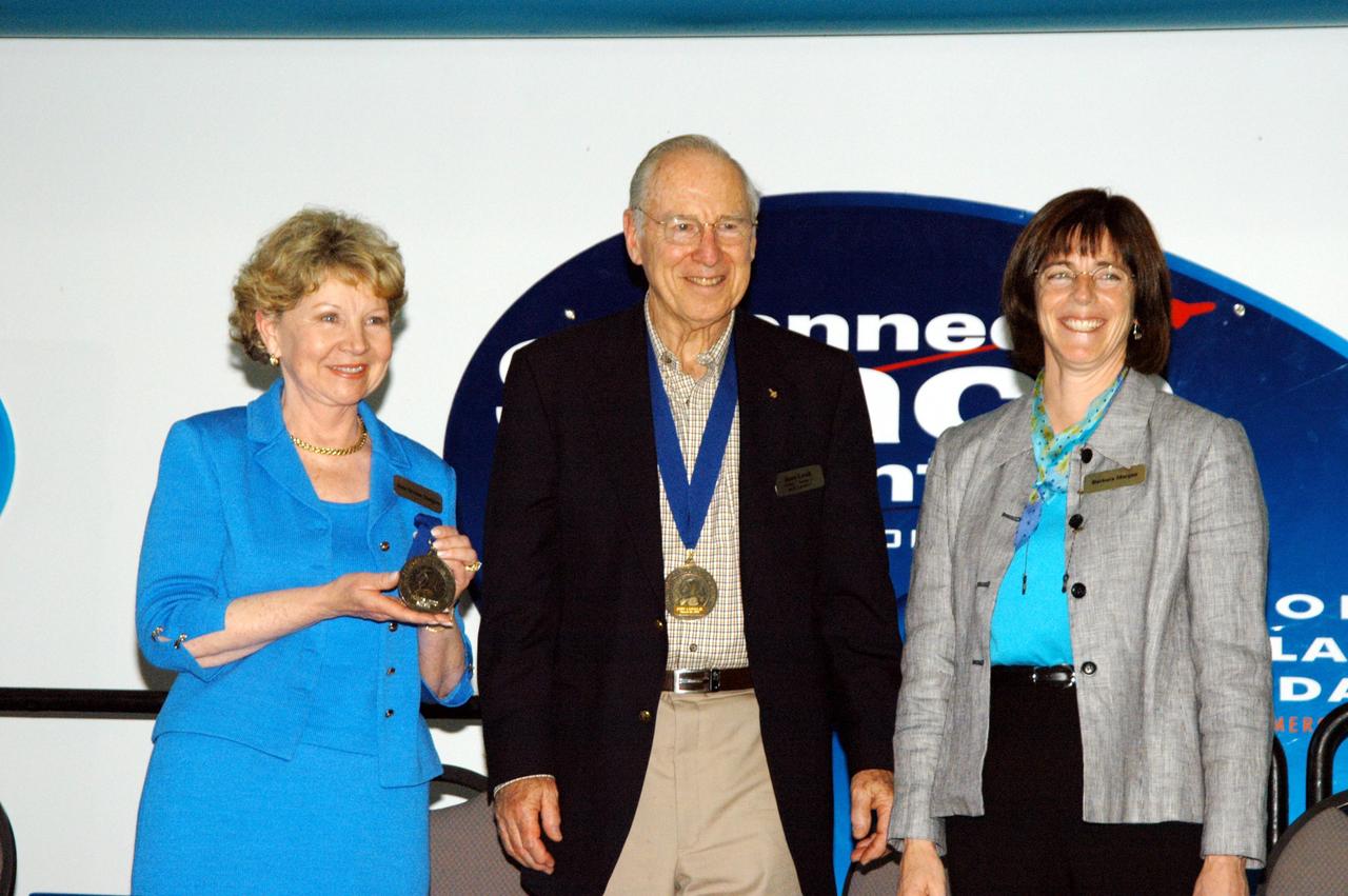 KENNEDY SPACE CENTER, FLA. -- At the Kennedy Space Center Visitor Complex, the late Francis R. "Dick" Scobee, commander of the ill-fated 1986 Challenger mission, is inducted into the U.S. Astronaut Hall of Fame. He is represented by his widow, June Scobee (left), who is accompanied by former NASA astronaut James A. Lovell Jr. and NASA astronaut Barbara R. Morgan. Morgan assumed the duties of Teacher in Space designee following the death of Christa McAuliffe, the teacher on the Challenger mission, and was selected by NASA in January 1998 as the first Educator Astronaut. Also chosen for induction in 2004 are Kathryn D. Sullivan, the first American woman to walk in space; Richard O. Covey, commander of the Hubble Space Telescope repair mission; Frederick D. Gregory, the first African-American to command a space mission; and Norman E. Thagard, the first American to occupy Russia's Mir space station. The U.S. Astronaut Hall of Fame opened in 1990 to provide a place where space travelers could be remembered for their participation and accomplishments in the U.S. space program. To be eligible for induction, an individual must have been a U.S. citizen, a NASA astronaut, and out of the active astronaut corps at least five years. The five inductees join 52 previously honored astronauts from the ranks of the Gemini, Apollo, Skylab, Apollo-Soyuz, and Space Shuttle programs.