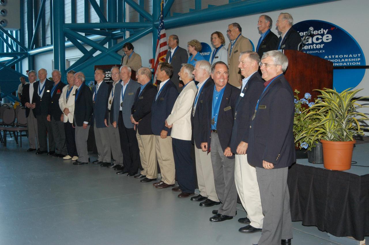 KENNEDY SPACE CENTER, FLA. -- Following the induction ceremony welcoming five new space program heroes in the U.S. Astronaut Hall of Fame, the members line up for a commemorative photo.  From left, in front, are John Young, John Glenn Jr., Scott Carpenter, Wally Schirra, Gordon Cooper, Walt Cunningham, Ed Mitchell, Al Worden, Rick Hauck, Ed Gibson, Owen Garriott, Vance Brand, Robert Crippen, Joe Engle, Dan Brandenstein. In back are space author Andrew Chaikin, at the podium; and Norm Thagard, June Scobee representing her late husband Dick Scobee, Kathryn Sullivan, Fred Gregory, Richard Covey and Jim Lovell.  The induction ceremony was held at the Apollo/Saturn V Center at KSC.  The U.S. Astronaut Hall of Fame opened in 1990 to provide a place where space travelers could be remembered for their participation and accomplishments in the U.S. space program. The five inductees join 52 previously honored astronauts from the ranks of the Gemini, Apollo, Skylab, Apollo-Soyuz, and Space Shuttle programs.