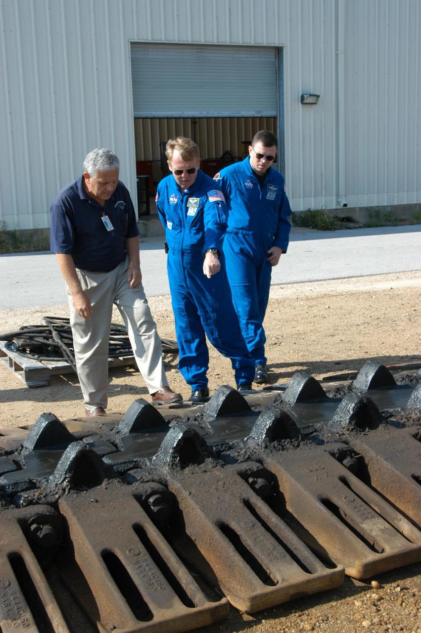 KENNEDY SPACE CENTER, FLA. -- STS-114 Mission Specialist Andrew Thomas (center) and Pilot James Kelly (right), along with NASA Systems Engineer Robert Rokobauer (left), look closely at the shoes of one of the tracks used on a Crawler-Transporter. The 10-foot-high track on a crawler contains 278 “shoes,” weighing 2,200 pounds each. The crawlers are guided by four trucks, one on each corner. The crawlers had recent modifications to the cab and muffler system. The STS-114 mission is Logistics Flight 1, which is scheduled to deliver supplies and equipment plus the external stowage platform to the International Space Station.
