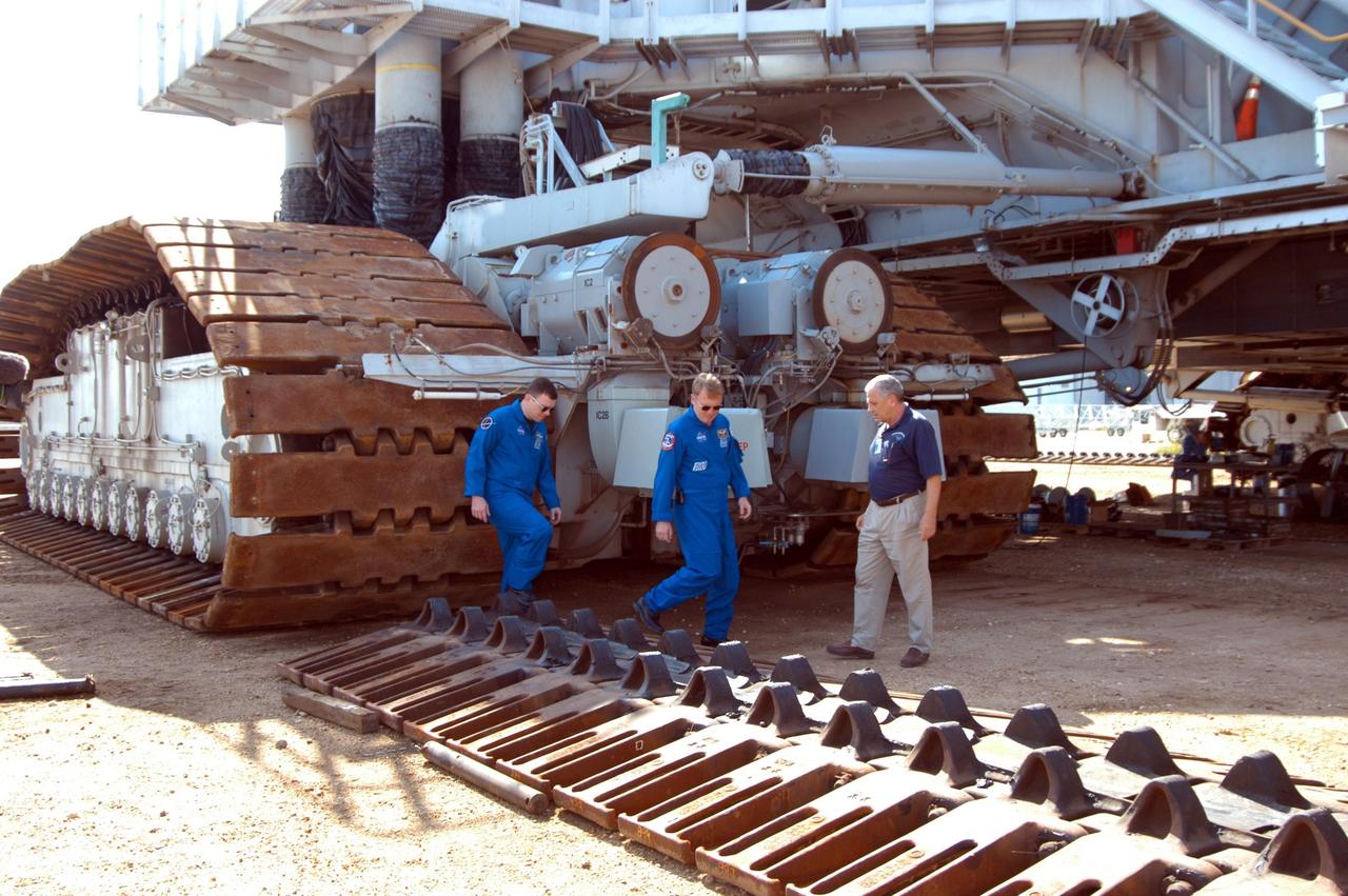 KENNEDY SPACE CENTER, FLA. -- STS-114 Pilot James Kelly (left) and Mission Specialist Andrew Thomas (center), along with NASA Systems Engineer Robert Rokobauer (right), look closely at the shoes of one of the tracks used on a Crawler-Transporter. The 10-foot-high track on a crawler contains 278 “shoes,” weighing 2,200 pounds each. The crawlers are guided by four trucks, one on each corner. The crawlers had recent modifications to the cab and muffler system. The STS-114 mission is Logistics Flight 1, which is scheduled to deliver supplies and equipment plus the external stowage platform to the International Space Station.