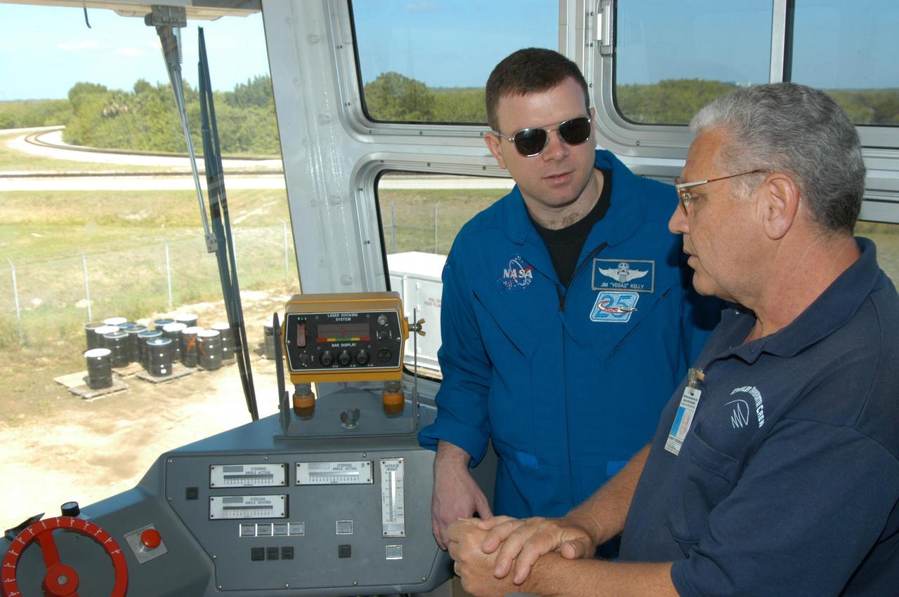 KENNEDY SPACE CENTER, FLA. -- STS-114 Pilot James Kelly (left) talks with NASA Systems Engineer Robert Rokobauer inside one of the cabs on a Crawler-Transporter. The crawlers had recent modifications to the cab and muffler system. The STS-114 mission is Logistics Flight 1, which is scheduled to deliver supplies and equipment plus the external stowage platform to the International Space Station.