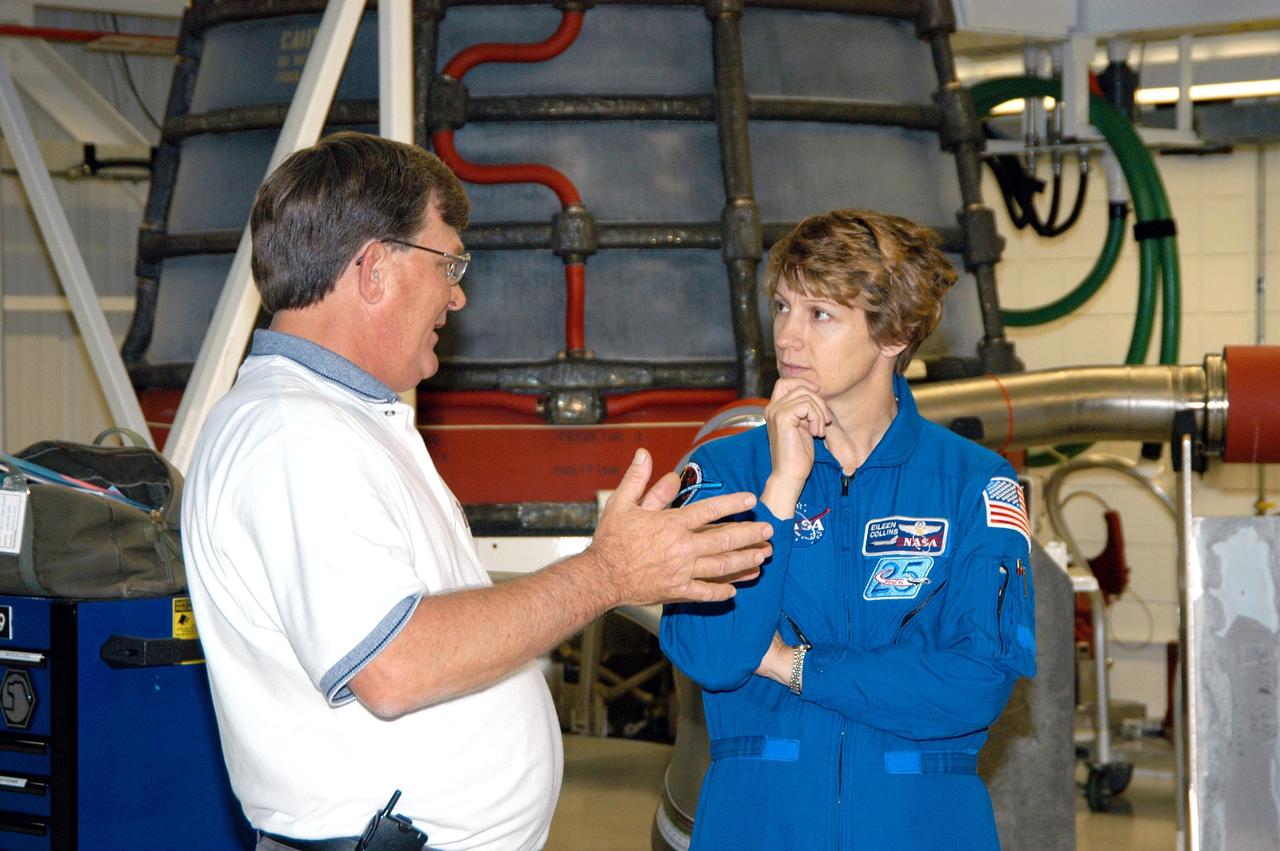 KENNEDY SPACE CENTER, FLA. -- In the Space Shuttle Main Engine Shop at KSC, Boeing Product Support Director Dan Hausman (left) talks with STS-114 Mission Commander Eileen Collins. Behind them is one of the main engines. Crew members are touring several areas on Center. The STS-114 mission is Logistics Flight 1, which is scheduled to deliver supplies and equipment plus the external stowage platform to the International Space Station.