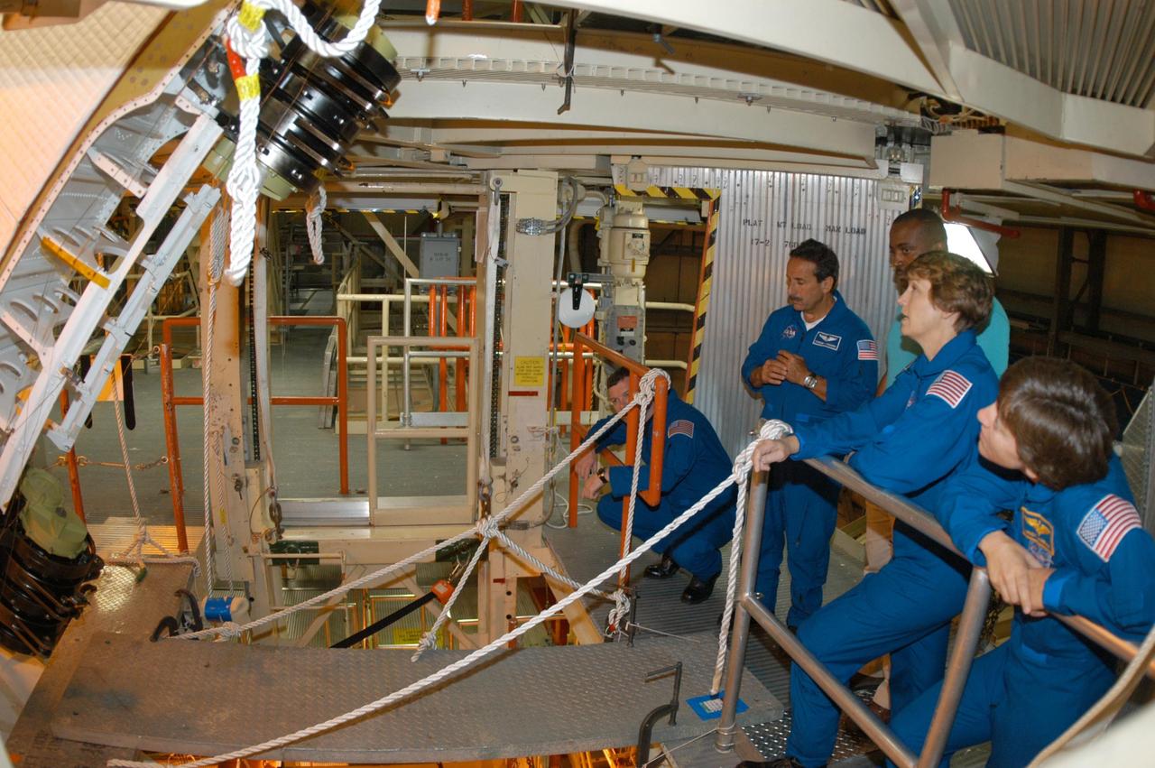 KENNEDY SPACE CENTER, FLA. -- In the Orbiter Processing Facility, STS-114 crew members look at one of the Rudder Speed Brake actuators. Seen at right are Mission Specialist Charles Camarda, Mission Commander Eileen Collins and Mission Specialist Wendy Lawrence. Crew members are touring several areas on Center. The STS-114 mission is Logistics Flight 1, which is scheduled to deliver supplies and equipment plus the external stowage platform to the International Space Station.