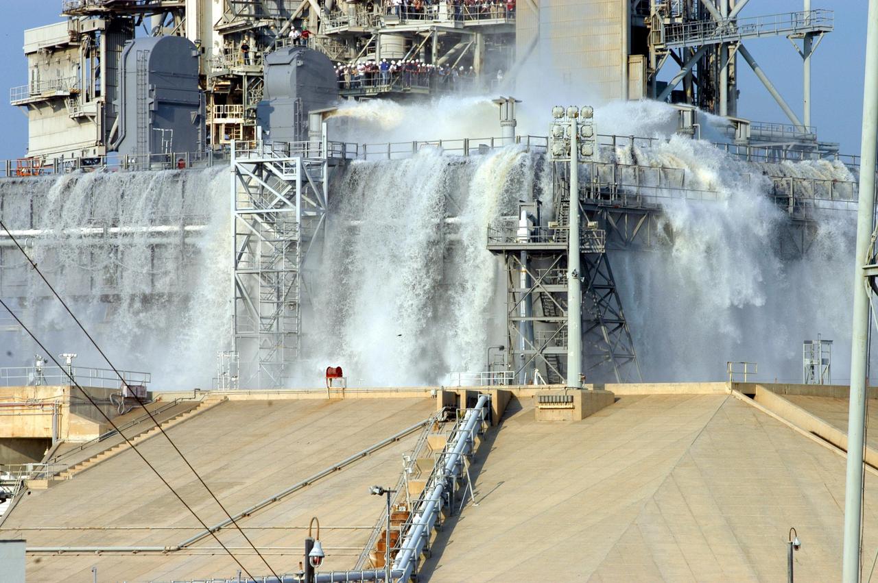 KENNEDY SPACE CENTER, FLA. -- For the fourth time in Space Shuttle Program history, 350,000 gallons of water are released on a Mobile Launcher Platform (MLP) at Launch Pad 39A during a water sound suppression test. This test is being conducted following the replacement of the six main system valves, which had been in place since the beginning of the Shuttle Program and had reached the end of their service life. Also, the hydraulic portion of the valve actuators has been redesigned and simplified to reduce maintenance costs. The sound suppression water system is installed on the launch pads to protect the orbiter and its payloads from damage by acoustical energy reflected from the MLP during launch. The system includes an elevated water tank with a capacity of 300,000 gallons. The tank is 290 feet high and stands on the northeast side of the Pad. The water is released just before the ignition of the orbiter's three main engines and twin solid rocket boosters, and flows through parallel 7-foot-diameter pipes to the Pad area.