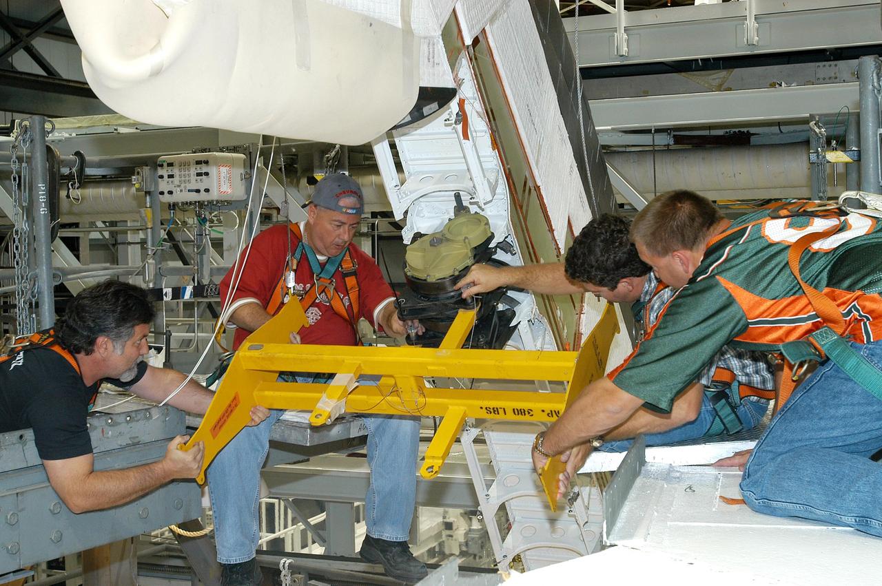 KENNEDY SPACE CENTER, FLA. -- Workers attach a crane to one of the Rudder Speed Brake Actuators that are being removed from the orbiter Atlantis for shipment to the vendor for inspection. An actuator is a motor that moves the tail rudder back and forth to help steer it during landing and brake its speed. The vertical tail consists of a structural fin surface made of aluminum, the Rudder Speed Brake surface, a tip and a lower trailing edge. The rudder splits into two halves to serve as a speed brake. The vertical tail and Rudder Speed Brake are covered with a reusable thermal protection system. Atlantis is undergoing maintenance and inspection in the Orbiter Processing Facility for a future mission.