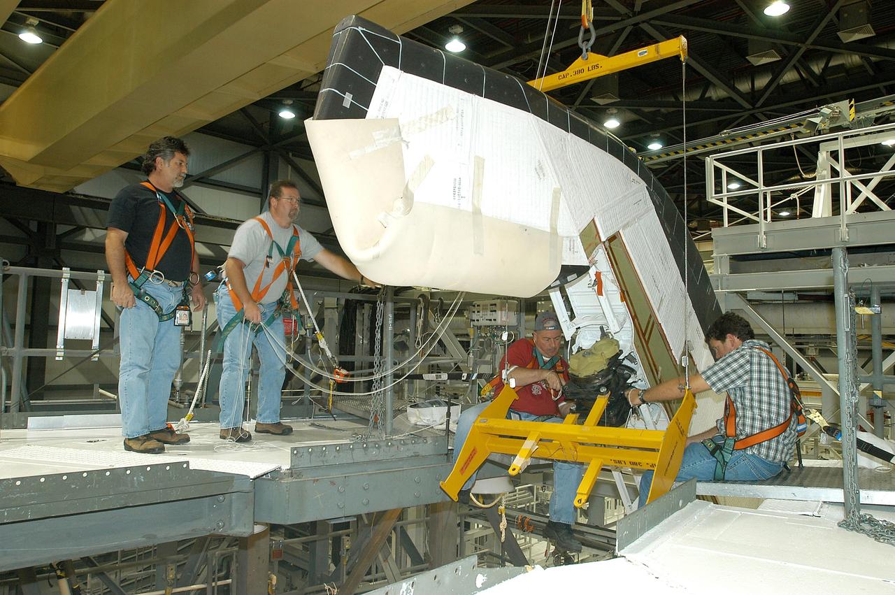 KENNEDY SPACE CENTER, FLA. -- Workers attach a crane to one of the Rudder Speed Brake Actuators that are being removed from the orbiter Atlantis for shipment to the vendor for inspection. An actuator is a motor that moves the tail rudder back and forth to help steer it during landing and brake its speed. The vertical tail consists of a structural fin surface made of aluminum, the Rudder Speed Brake surface, a tip and a lower trailing edge. The rudder splits into two halves to serve as a speed brake. The vertical tail and Rudder Speed Brake are covered with a reusable thermal protection system. Atlantis is undergoing maintenance and inspection in the Orbiter Processing Facility for a future mission.