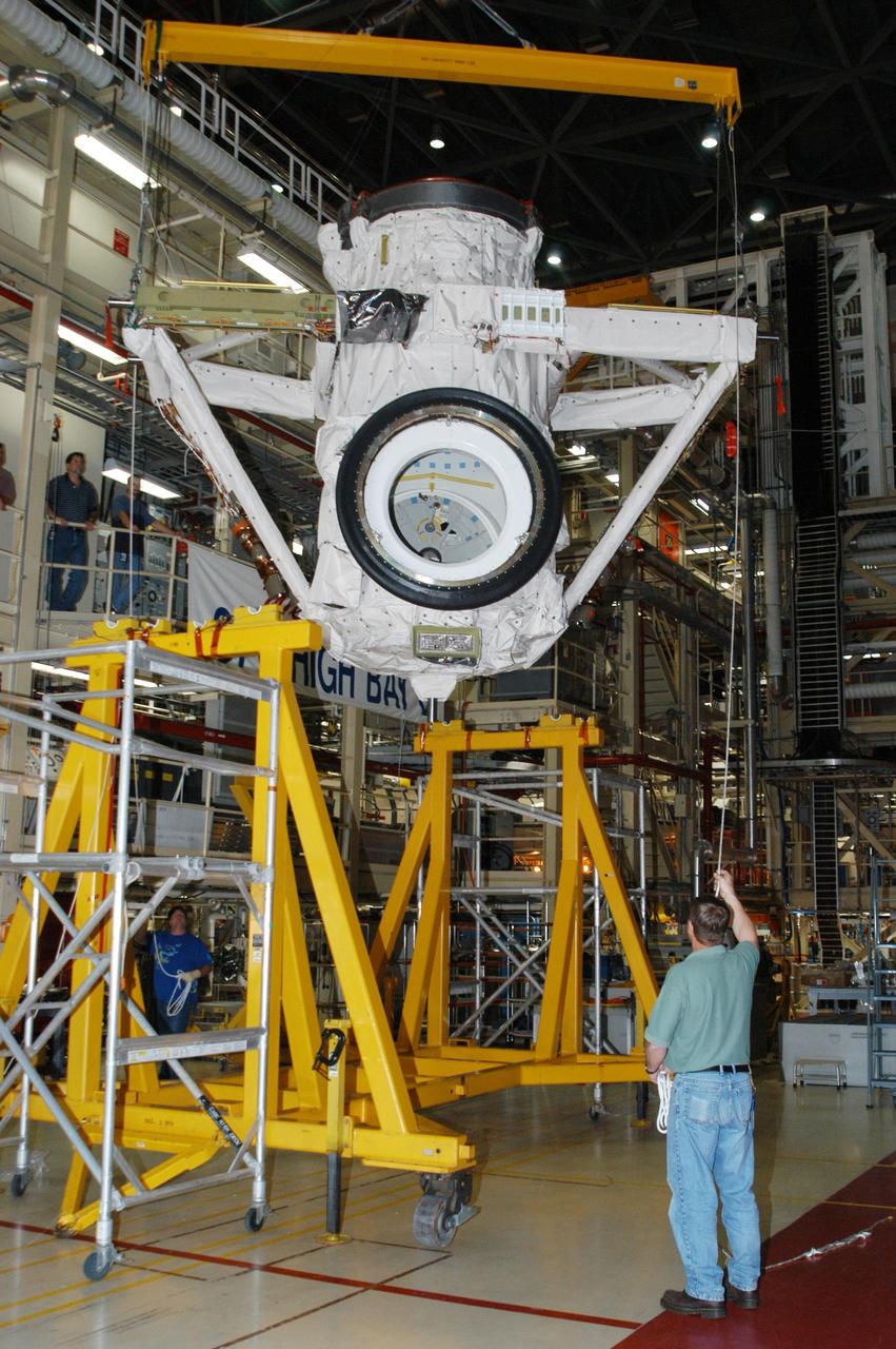 KENNEDY SPACE CENTER, FLA. -- Discovery’s airlock is lifted toward the orbiter for installation inside the orbiter’s payload bay.  The airlock is sized to accommodate two fully suited flight crew members simultaneously.  Support functions include airlock depressurization and repressurization, extravehicular activity equipment recharge, liquid-cooled garment water cooling, EVA equipment checkout, and communications.  Discovery is designated as the Return to Flight vehicle for mission STS-114, no earlier than March 2005.  STS-114 mission is Logistics Flight 1, which is scheduled to deliver supplies and equipment plus the external stowage platform to the International Space Station.
