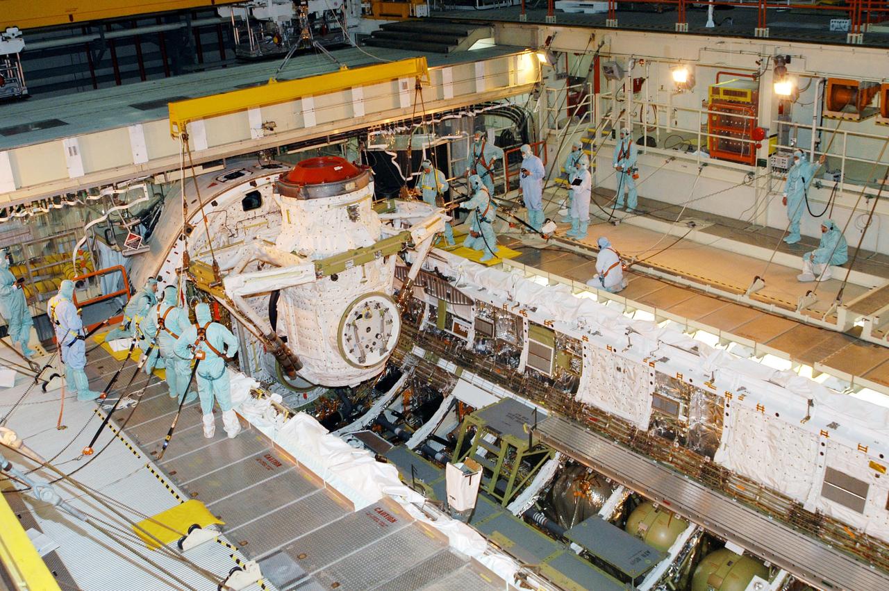 KENNEDY SPACE CENTER, FLA. -- Discovery’s airlock is lowered into the orbiter’s payload bay for installation.  The airlock is sized to accommodate two fully suited flight crew members simultaneously.  Support functions include airlock depressurization and repressurization, extravehicular activity equipment recharge, liquid-cooled garment water cooling, EVA equipment checkout, and communications.  Discovery is designated as the Return to Flight vehicle for mission STS-114, no earlier than March 2005.  STS-114 mission is Logistics Flight 1, which is scheduled to deliver supplies and equipment plus the external stowage platform to the International Space Station.