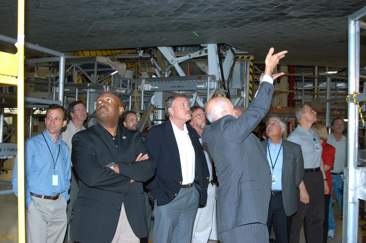 KENNEDY SPACE CENTER, FLA. -- Adm. Craig E. Steidle (center), NASA’s associate administrator, Office of Exploration Systems, tours the Orbiter Processing Facility on a visit to KSC.  At right (hands up) is Conrad Nagel, chief of the Shuttle Project Office.  They are standing under the orbiter Discovery.  The Office of Exploration Systems was established to set priorities and direct the identification, development and validation of exploration systems and related technologies to support the future space vision for America.  Steidle’s visit included a tour of KSC to review the facilities and capabilities to be used to support the vision.