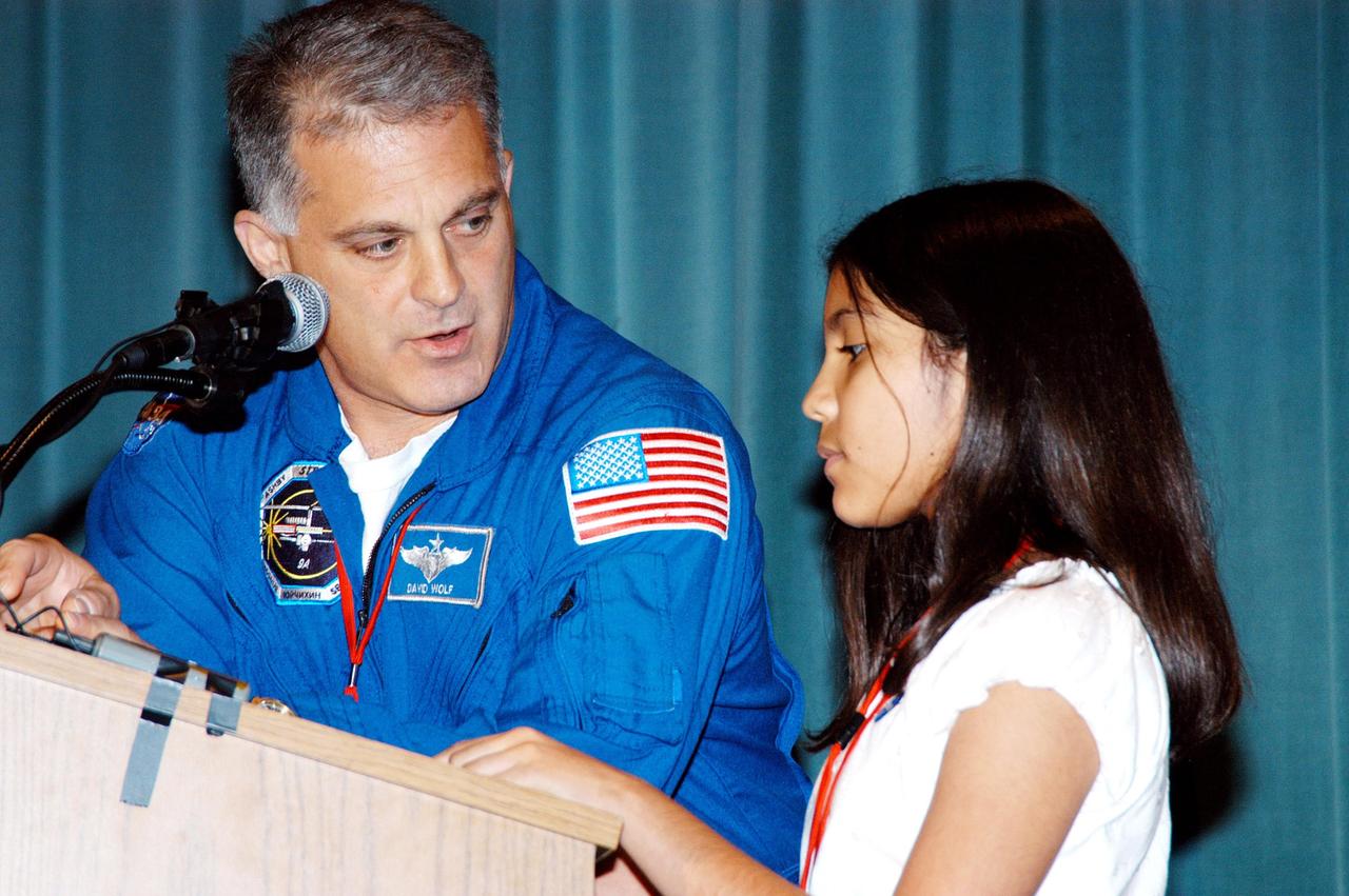 KENNEDY SPACE CENTER, FLA. -- Astronaut David Wolf answers questions from a student on stage at Howard A. Doolin Middle School, Miami, Fla., during his talk about his experiences in space. Doolin Middle School is one of 100 to take part in the NASA Explorer Schools (NES) program. Wolf joins Center Director Jim Kennedy (seated at lower left) on his visit to share America’s new vision for space exploration with the next generation of explorers. He is talking with students in Florida and Georgia Explorer Schools about our destiny as explorers, NASA’s stepping stone approach to exploring Earth, the Moon, Mars and beyond, how space impacts our lives, and how people and machines rely on each other in space.
