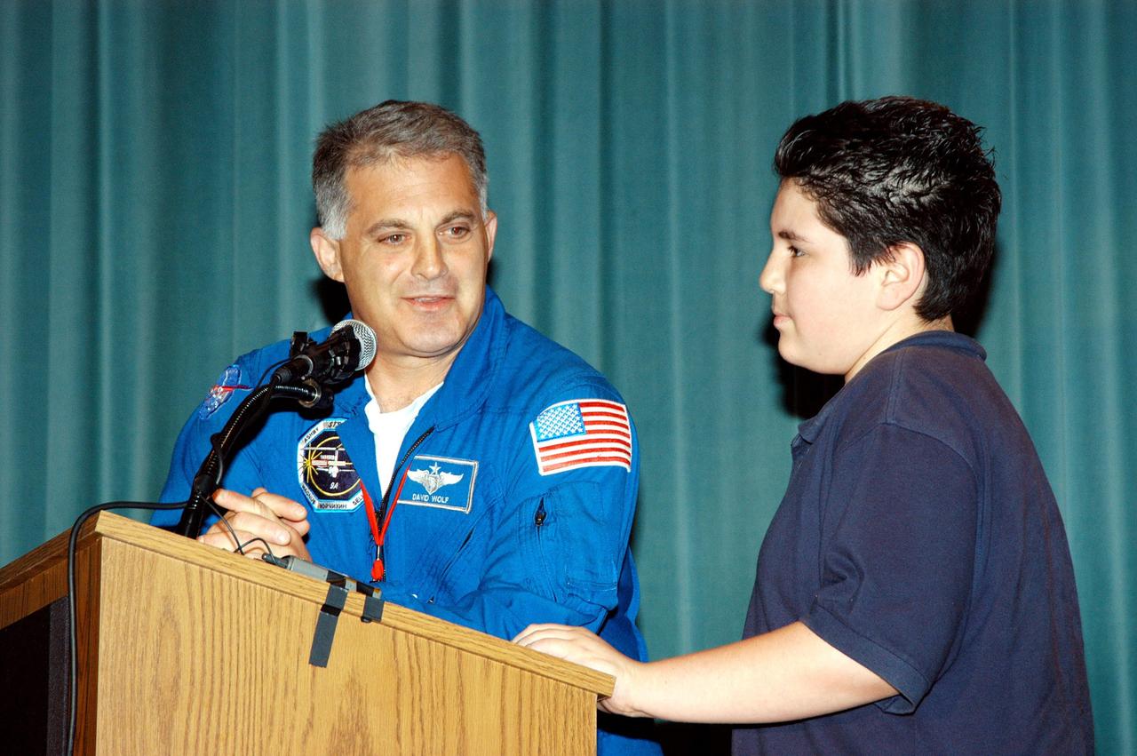 KENNEDY SPACE CENTER, FLA. -- Astronaut David Wolf answers questions from a student on stage at Howard A. Doolin Middle School, Miami, Fla., during his talk about his experiences in space. Doolin Middle School is one of 100 to take part in the NASA Explorer Schools (NES) program. Wolf joins Center Director Jim Kennedy (seated at lower left) on his visit to share America’s new vision for space exploration with the next generation of explorers. He is talking with students in Florida and Georgia Explorer Schools about our destiny as explorers, NASA’s stepping stone approach to exploring Earth, the Moon, Mars and beyond, how space impacts our lives, and how people and machines rely on each other in space.