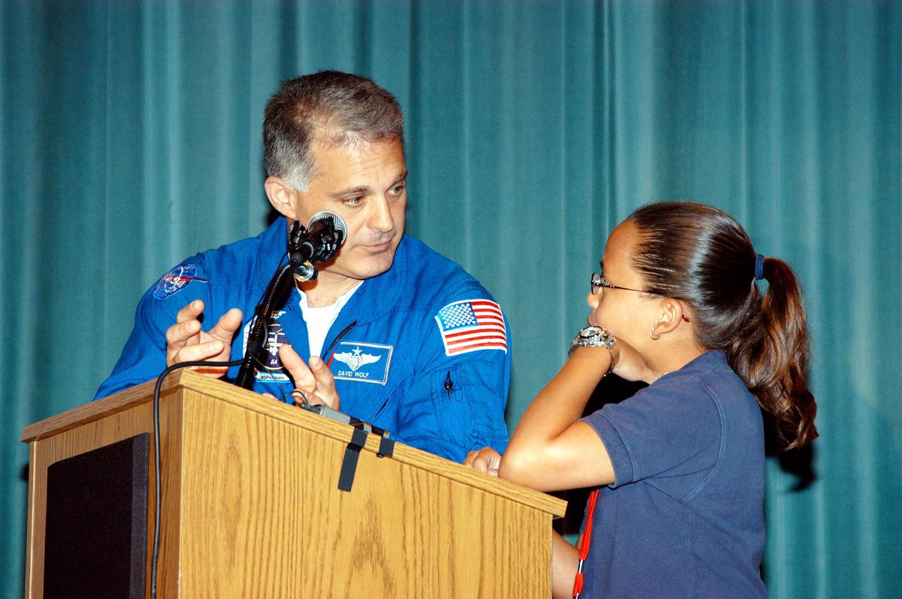 KENNEDY SPACE CENTER, FLA. -- Astronaut David Wolf answers questions from a student on stage at Howard A. Doolin Middle School, Miami, Fla., during his talk about his experiences in space. Doolin Middle School is one of 100 to take part in the NASA Explorer Schools (NES) program. Wolf joins Center Director Jim Kennedy (seated at lower left) on his visit to share America’s new vision for space exploration with the next generation of explorers. He is talking with students in Florida and Georgia Explorer Schools about our destiny as explorers, NASA’s stepping stone approach to exploring Earth, the Moon, Mars and beyond, how space impacts our lives, and how people and machines rely on each other in space.