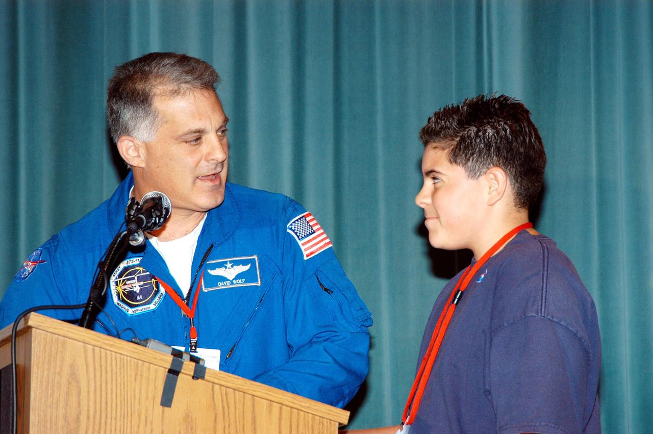 KENNEDY SPACE CENTER, FLA. -- Astronaut David Wolf answers questions from a student on stage at Howard A. Doolin Middle School, Miami, Fla., during his talk about his experiences in space. Doolin Middle School is one of 100 to take part in the NASA Explorer Schools (NES) program. Wolf joins Center Director Jim Kennedy (seated at lower left) on his visit to share America’s new vision for space exploration with the next generation of explorers. He is talking with students in Florida and Georgia Explorer Schools about our destiny as explorers, NASA’s stepping stone approach to exploring Earth, the Moon, Mars and beyond, how space impacts our lives, and how people and machines rely on each other in space.