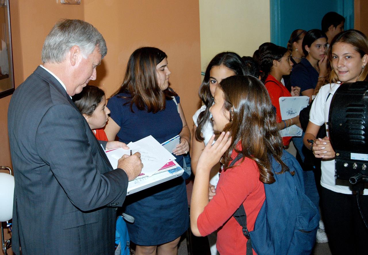 KENNEDY SPACE CENTER, FLA. -- After his presentation, Center Director Jim Kennedy signs a memento for a student at Howard A. Doolin Middle School, Miami, Fla. The school is one of 100 taking part in the NASA Explorer Schools (NES) program. Kennedy visited the school to share America’s new vision for space exploration with the next generation of explorers. He is talking with students in Florida and Georgia Explorer Schools about our destiny as explorers, NASA’s stepping stone approach to exploring Earth, the Moon, Mars and beyond, how space impacts our lives, and how people and machines rely on each other in space.