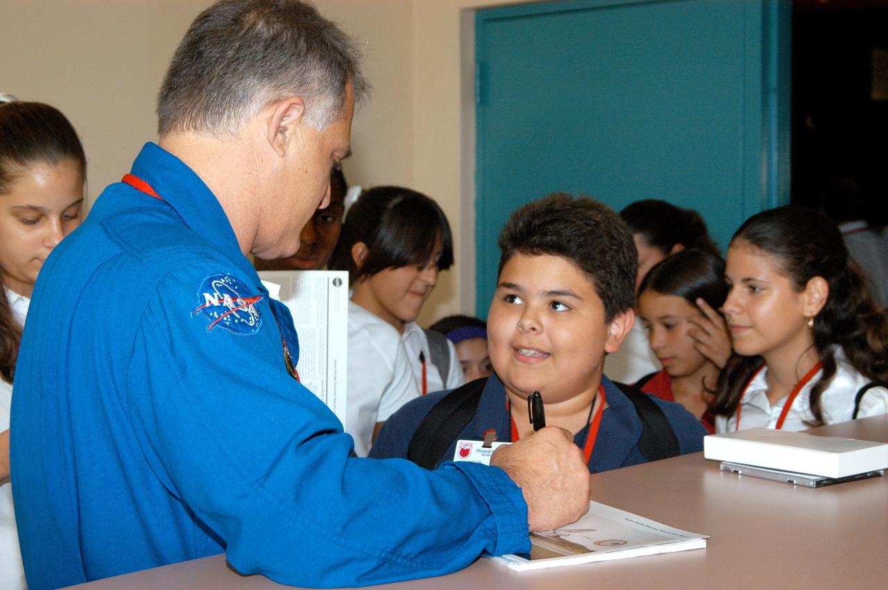 KENNEDY SPACE CENTER, FLA. -- After his presentation at Howard A. Doolin Middle School, Miami, Fla., astronaut David Wolf signs a memento for a student. The school is one of 100 taking part in the NASA Explorer Schools (NES) program. Center Director Jim Kennedy and Wolf visited the school to share America’s new vision for space exploration with the next generation of explorers. They talked with students about our destiny as explorers, NASA’s stepping stone approach to exploring Earth, the Moon, Mars and beyond, how space impacts our lives, and how people and machines rely on each other in space.