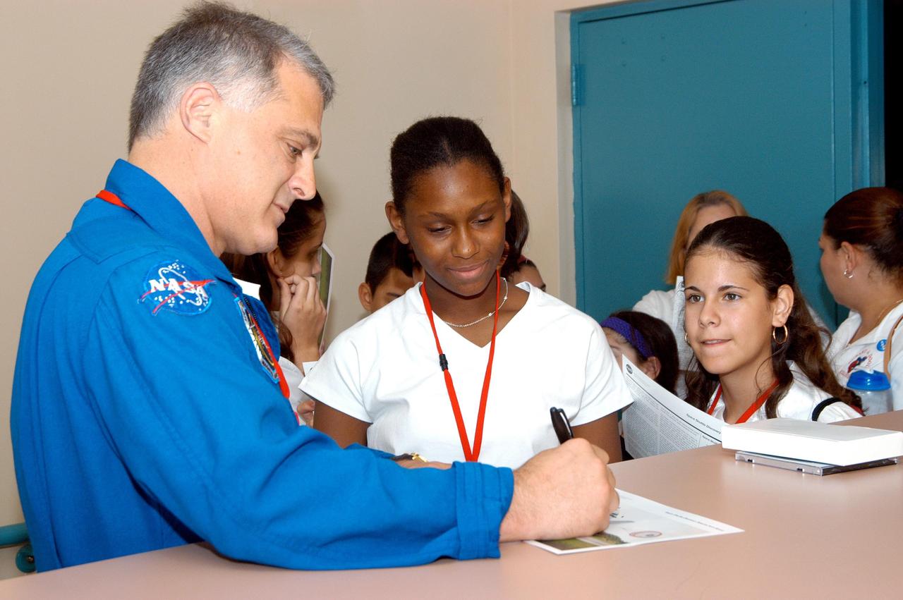 KENNEDY SPACE CENTER, FLA. -- After his presentation at Howard A. Doolin Middle School, Miami, Fla., astronaut David Wolf signs a memento for a student. The school is one of 100 taking part in the NASA Explorer Schools (NES) program. Center Director Jim Kennedy and Wolf visited the school to share America’s new vision for space exploration with the next generation of explorers. They talked with students about our destiny as explorers, NASA’s stepping stone approach to exploring Earth, the Moon, Mars and beyond, how space impacts our lives, and how people and machines rely on each other in space.