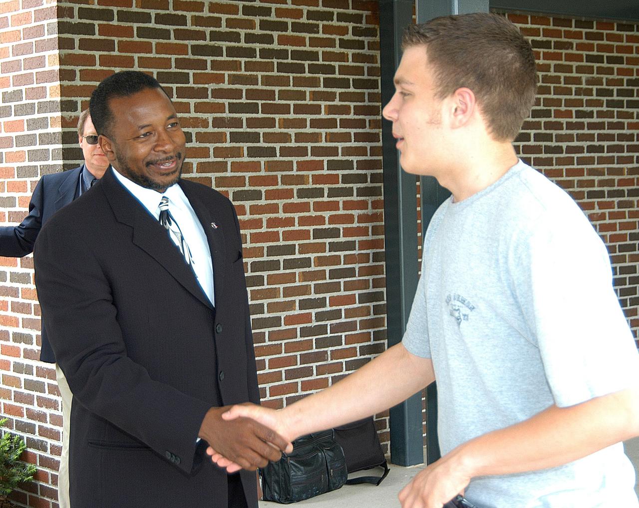 KENNEDY SPACE CENTER, FLA. -- Dr. Woodrow Whitlow, KSC deputy director, greets a student outside Trojan Intermediate School in Potosi, Mo. Students from three area schools — Potosi High School, John Evans Middle School and Trojan — are on a team taking part in NASA’s Explorer Schools program. Whitlow visited the school to share America’s new vision for space exploration with the next generation of explorers. He is talking with students about our destiny as explorers, NASA’s stepping stone approach to exploring Earth, the Moon, Mars and beyond, how space impacts our lives, and how people and machines rely on each other in space.