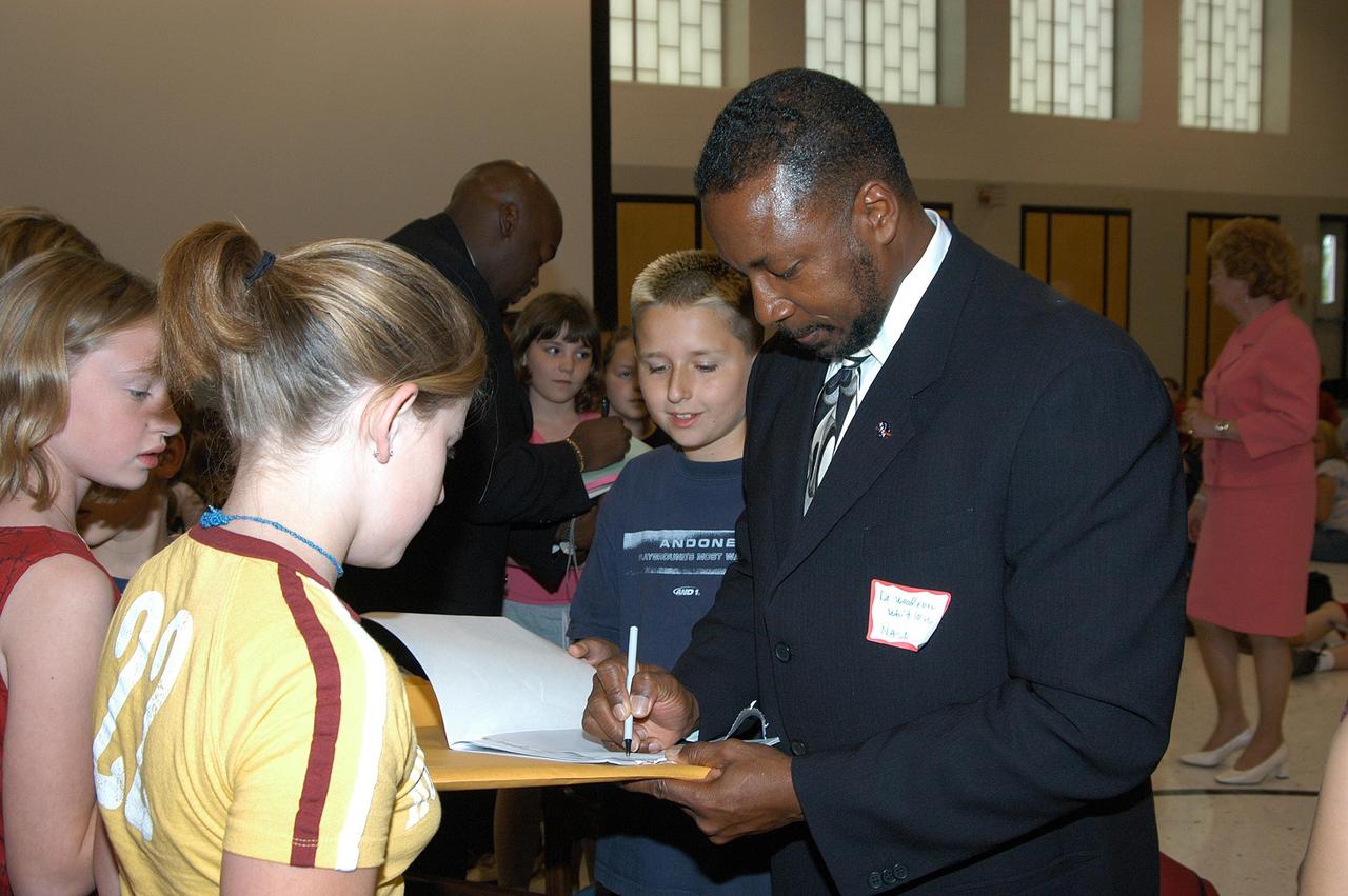 KENNEDY SPACE CENTER, FLA. -- KSC Deputy Director Dr. Woodrow Whitlow signs autographs for students at Trojan Intermediate School in Potosi, Mo.  Students from three area schools — Potosi High School, John Evans Middle School and Trojan — are on a team taking part in NASA’s Explorer Schools program.  Whitlow visited the school to share America’s new vision for space exploration with the next generation of explorers. He is talking with students about our destiny as explorers, NASA’s stepping stone approach to exploring Earth, the Moon, Mars and beyond, how space impacts our lives, and how people and machines rely on each other in space.