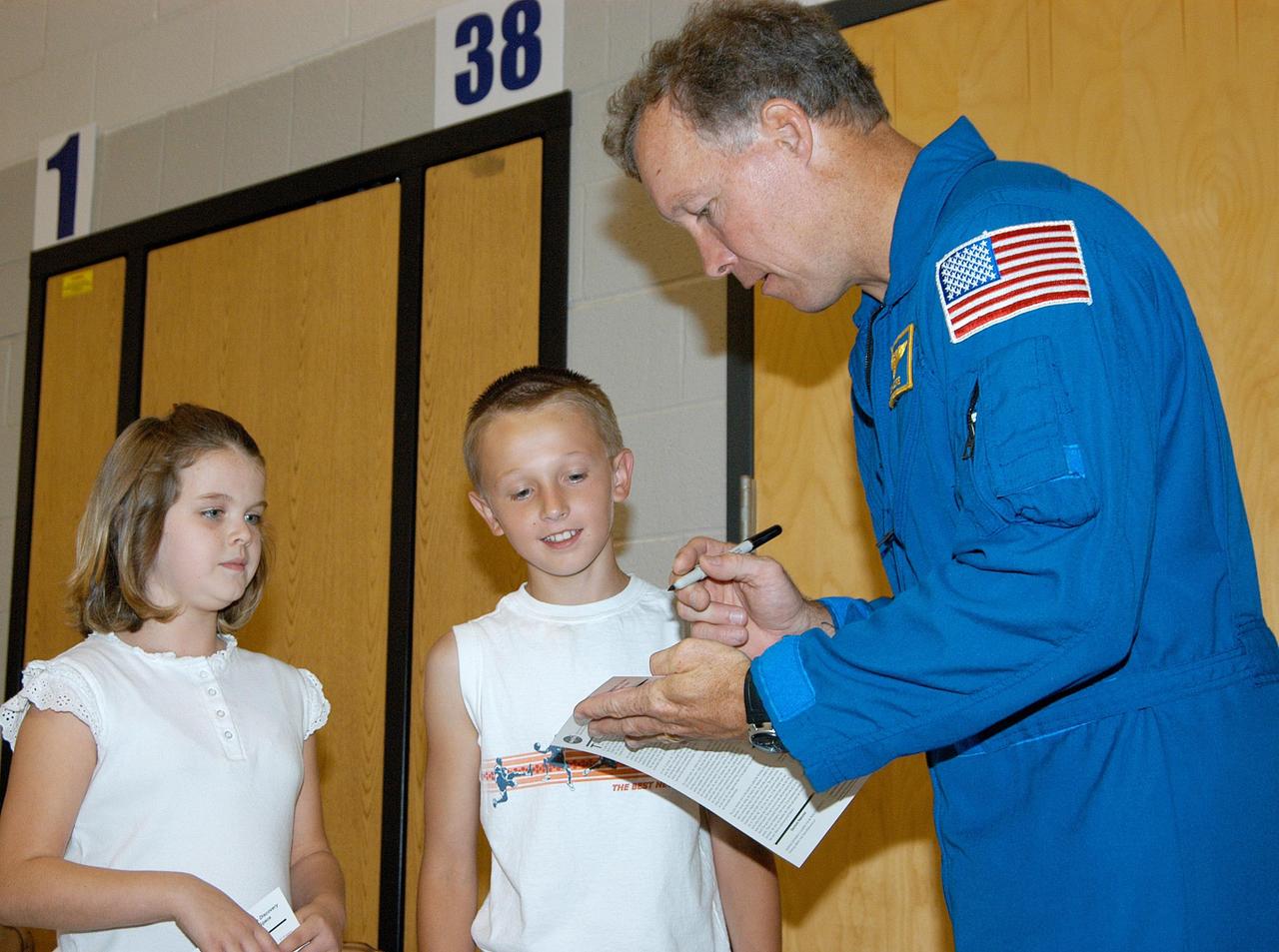 KENNEDY SPACE CENTER, FLA. -- Astronaut Dom Gorie signs autographs for students at Trojan Intermediate School in Potosi, Mo.  Gorie accompanied KSC Deputy Director Dr. Woodrow Whitlow on a visit to the school to share America’s new vision for space exploration with the next generation of explorers. They are talking with students about our destiny as explorers, NASA’s stepping stone approach to exploring Earth, the Moon, Mars and beyond, how space impacts our lives, and how people and machines rely on each other in space.  Students from three area schools — Potosi High School, John Evans Middle School and Trojan — are on a team taking part in NASA’s Explorer Schools program.