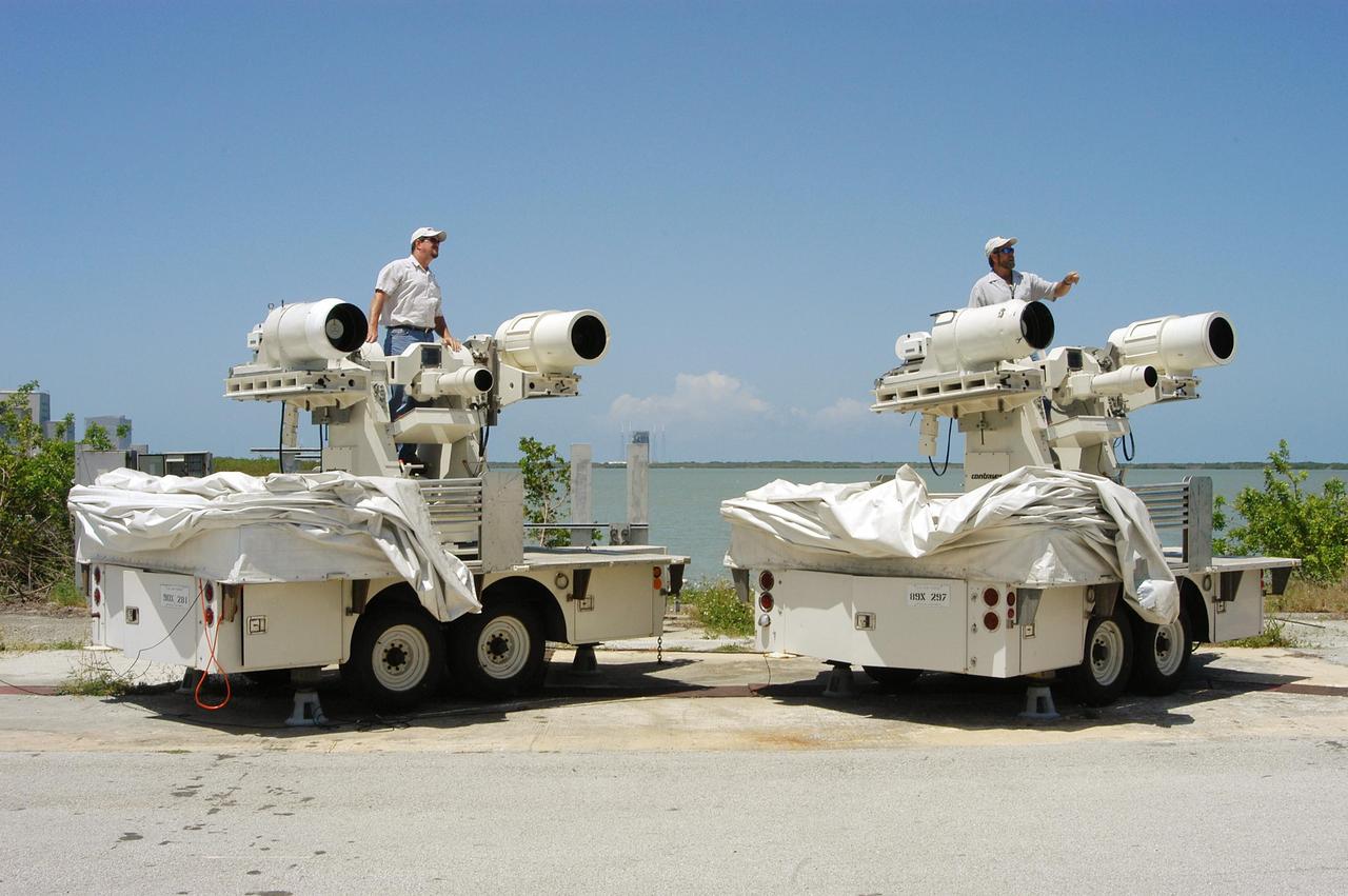 KENNEDY SPACE CENTER, FLA. -- Johnson Controls operators Rick Wetherington (left) and Kenny Allen work on two of the recently acquired Contraves-Goerz Kineto Tracking Mounts (KTM). There are 10 KTMs certified for use on the Eastern Range. The KTM, which is trailer-mounted with a center console/seat and electric drive tracking mount, includes a two-camera, camera control unit that will be used during launches. The KTM is designed for remotely controlled operations and offers a combination of film, shuttered and high-speed digital video, and FLIR cameras configured with 20-inch to 150-inch focal length lenses. The KTMs are generally placed in the field and checked out the day before a launch and manned 3 hours prior to liftoff.
