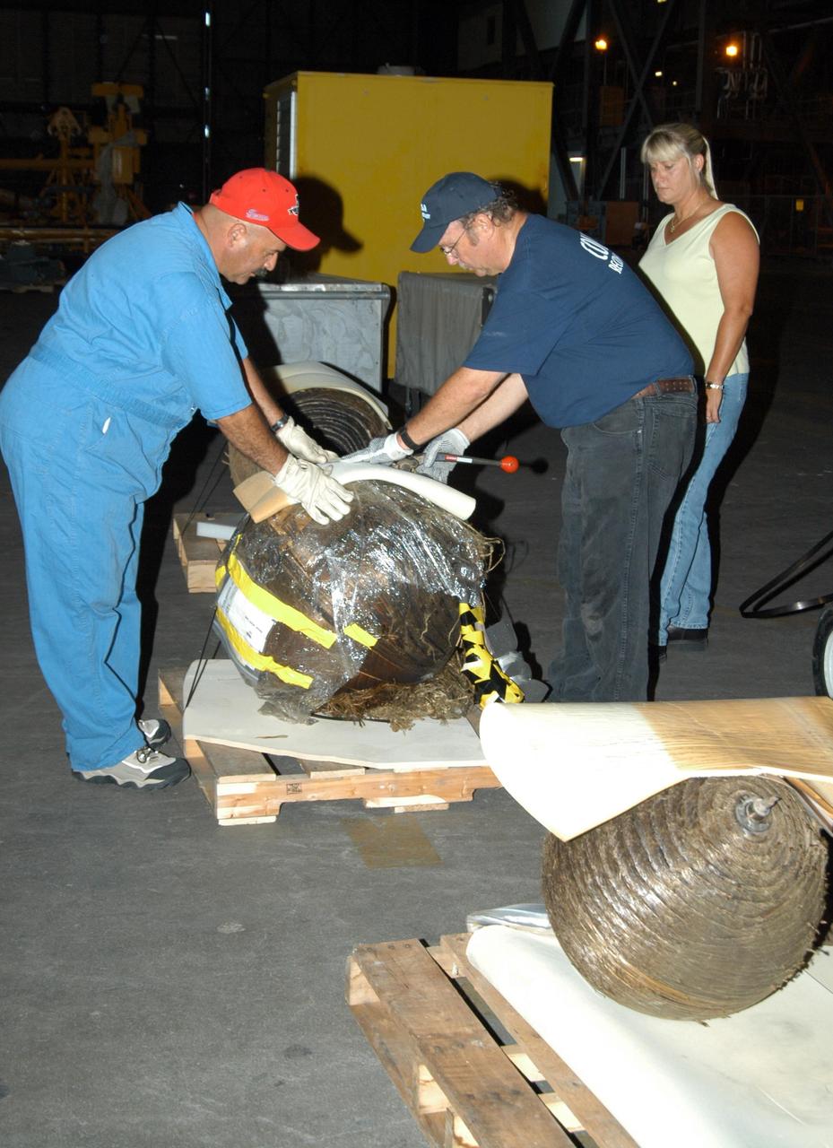 KENNEDY SPACE CENTER, FLA.  -  United Space Alliance workers begin packing pieces of Columbia debris for shipment to The Aerospace Corporation in El Segundo, Calif.   The pieces have been released for loan to the non-governmental agency for testing and research.   The Aerospace Corporation requested and will receive graphite/epoxy honeycomb skins from an Orbital Maneuvering System pod, Main Propulsion System Helium tanks, a Reaction Control System Helium tank and a Power Reactant Storage Distribution system tank. The company will use the parts to study re-entry effects on composite materials. NASA notified the Columbia crew’s families about the loan before releasing the items for study.  Researchers believe the testing will show how materials are expected to respond to various heating and loads' environments. The findings will help calibrate tools and models used to predict hazards to people and property from reentering hardware. The Aerospace Corporation will have the debris for one year to perform analyses to estimate maximum temperatures during reentry based upon the geometry and mass of the recovered composite.  Columbia’s debris is stored in the VAB.