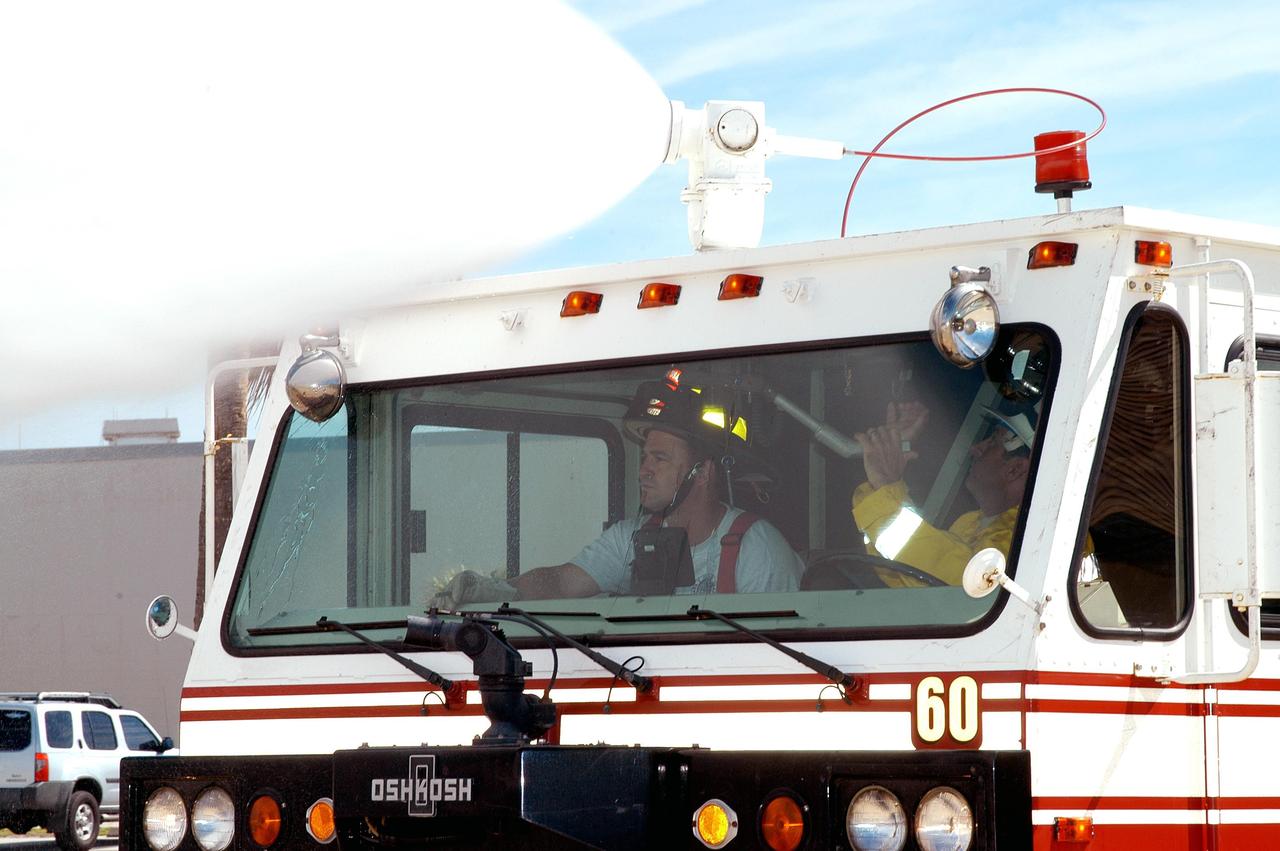 KENNEDY SPACE CENTER, FLA.  -  At Cape Canaveral Air Force Station, Firefighter Chris Maupin (left) and Lt. Keith Abell demonstrate how the special aircraft firefighting vehicle (known as ARF) was used at the site of a recent fire in Brevard County, Fla. The firefighters sit inside the vehicle with a "driver" in the middle. They are able to direct the hoses to attack fires from above and below.  The firefighters teamed up with task forces from Satellite Beach, Malabar, Melbourne, Palm Bay, Patrick Air Force Base and Brevard County to help fight wildfires in the Palm Bay and Malabar areas that threatened homes and property during the Memorial Day holiday weekend.