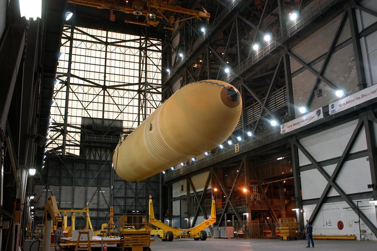 KENNEDY SPACE CENTER, FLA.  -  An external tank is lowered toward a transporter in the transfer aisle of the Vehicle Assembly Building.  The tank is being transferred to the Michoud Space Systems Assembly Facility near New Orleans where redesign of the external tank is underway for Return to Flight.