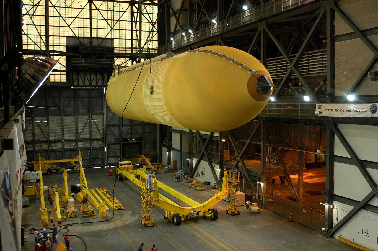 KENNEDY SPACE CENTER, FLA.  -  An external tank is lowered toward a transporter in the transfer aisle of the Vehicle Assembly Building.  The tank is being transferred to the Michoud Space Systems Assembly Facility near New Orleans where redesign of the external tank is underway for Return to Flight.