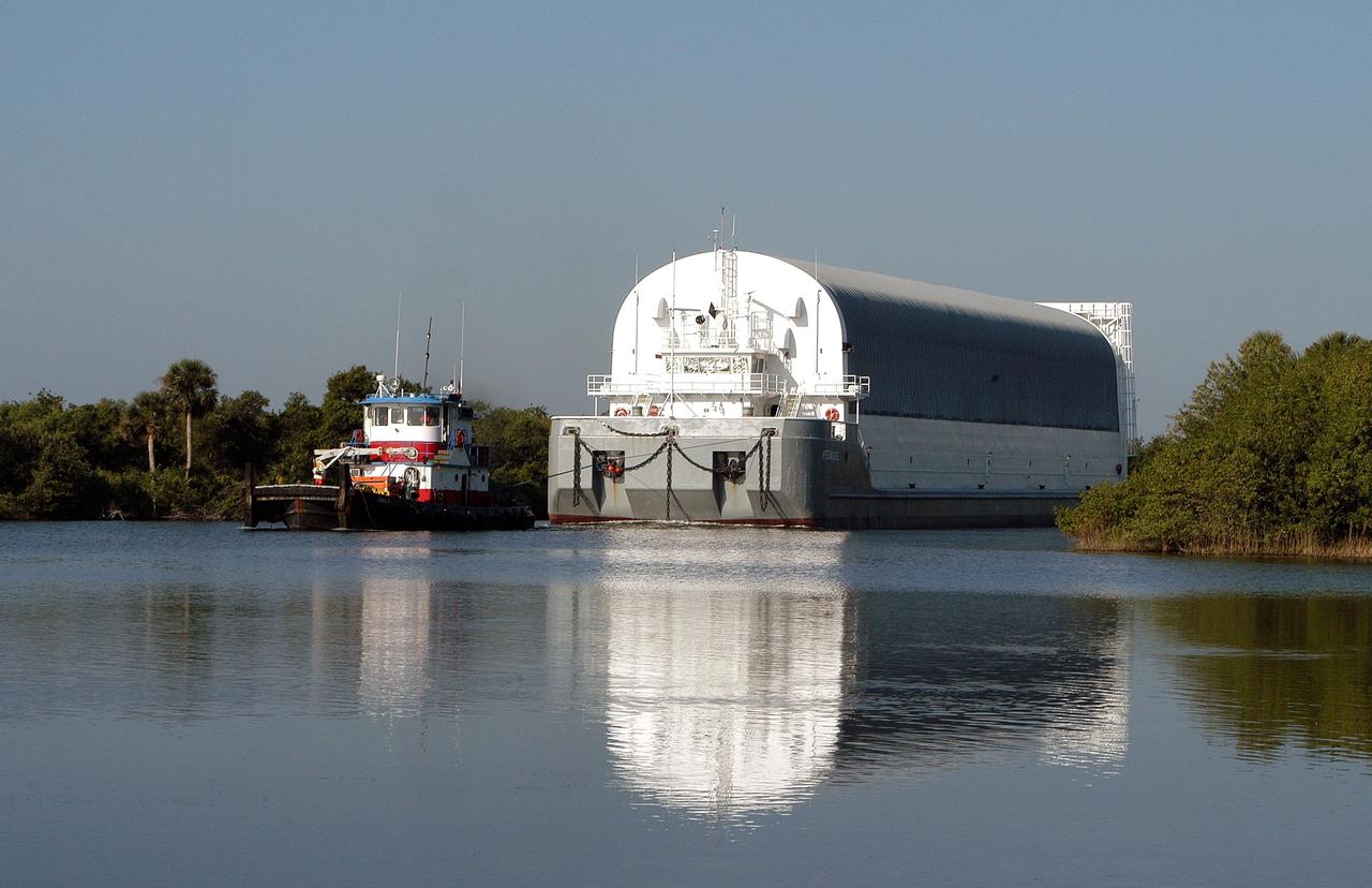 KENNEDY SPACE CENTER, FLA.  - A tug boat begins towing the barge containing an External Tank (ET) to Port Canaveral. There one of the SRB Retrieval Ships will take over and tow the ET to the Michoud Space Systems Assembly Facility near New Orleans where redesign of the external tank is underway for Return to Flight.