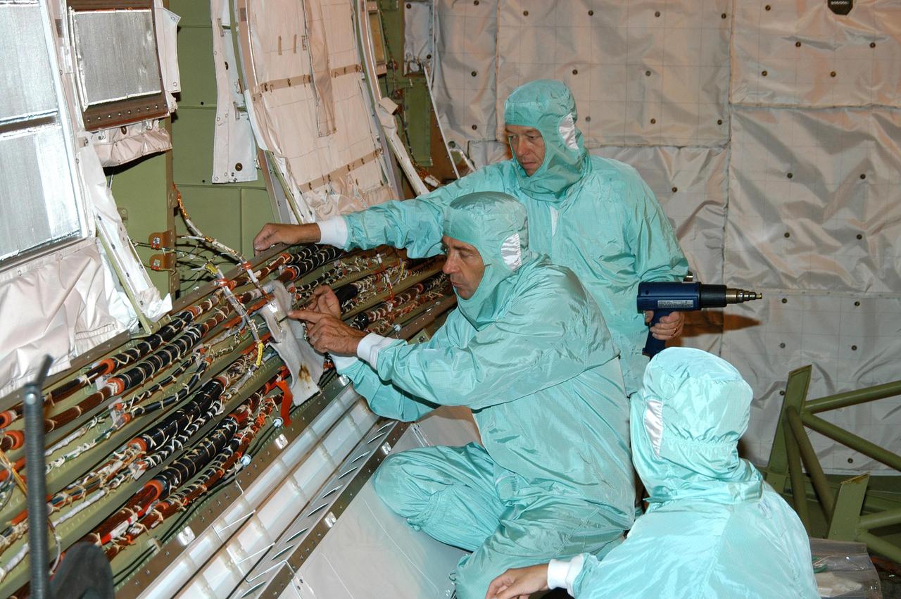 KENNEDY SPACE CENTER, FLA.  - In the Orbiter Processing Facility, workers are installing in Discovery’s cargo bay wiring that will support the addition of an Orbiter Boom Sensor System (OBSS).  The OBSS is one of the new safety measures for Return to Flight, equipping the Shuttle with cameras and laser systems to inspect the Shuttle’s Thermal Protection System while in space.  Discovery is designated as the Return to Flight vehicle for mission STS-114, no earlier than March 2005.