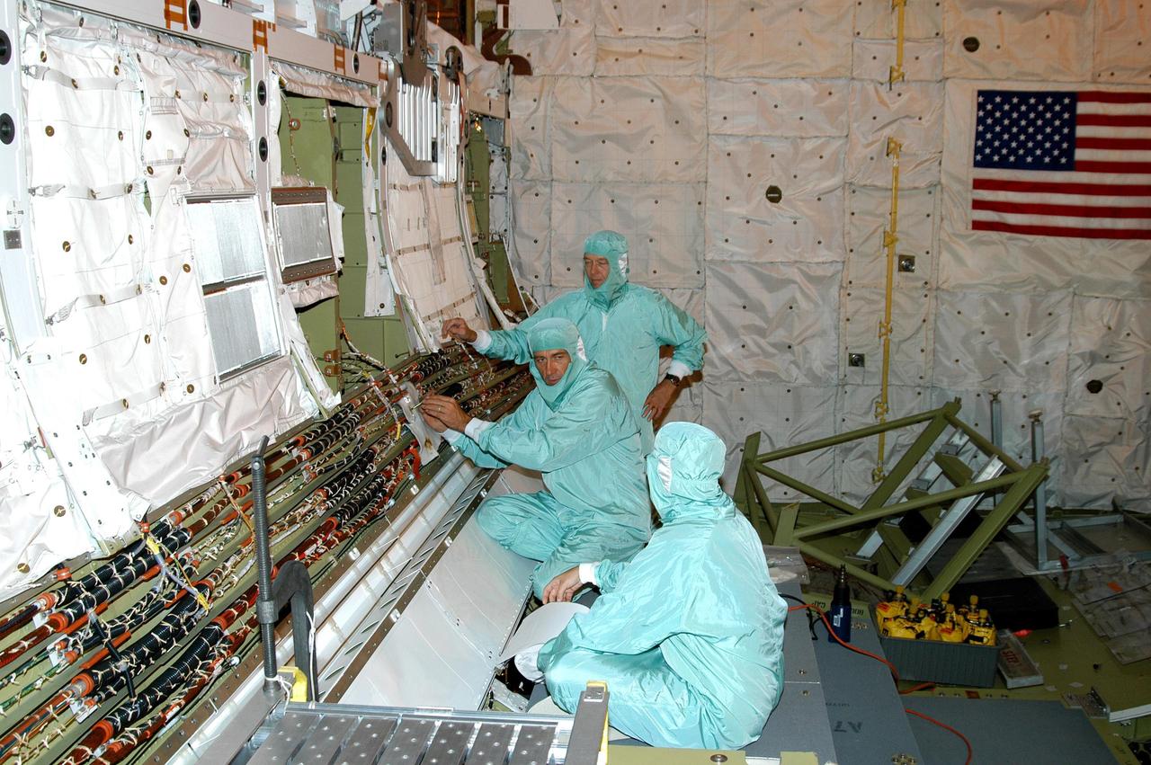 KENNEDY SPACE CENTER, FLA.  - In the Orbiter Processing Facility, workers are installing wiring in Discovery’s cargo bay that will support the addition of an Orbiter Boom Sensor System (OBSS) .  The OBSS is one of the new safety measures for Return to Flight, equipping the Shuttle with cameras and laser systems to inspect the Shuttle’s Thermal Protection System while in space.  Discovery is designated as the Return to Flight vehicle for mission STS-114, no earlier than March 2005.