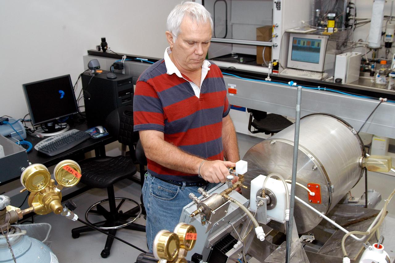 KENNEDY SPACE CENTER, FLA. - In the KSC Space Life Sciences Lab, Dr. Richard Strayer, a microbial research scientist with Dynamac at KSC, works on the Research Space Bioconverter. The apparatus is a rotating drum composter that contains waste for decomposition. Strayer is experimenting with a process called denitrification, in which organisms use nitrate instead of oxygen to break down the waste and produce nitrogen as a byproduct. This process, anaerobic respiration using nitrate, has never been tried in composting and is achieving promising results. The Lab is exploring various aspects of a bioregenerative life support system. Such research and technology development will be crucial to long-term habitation of space by humans.