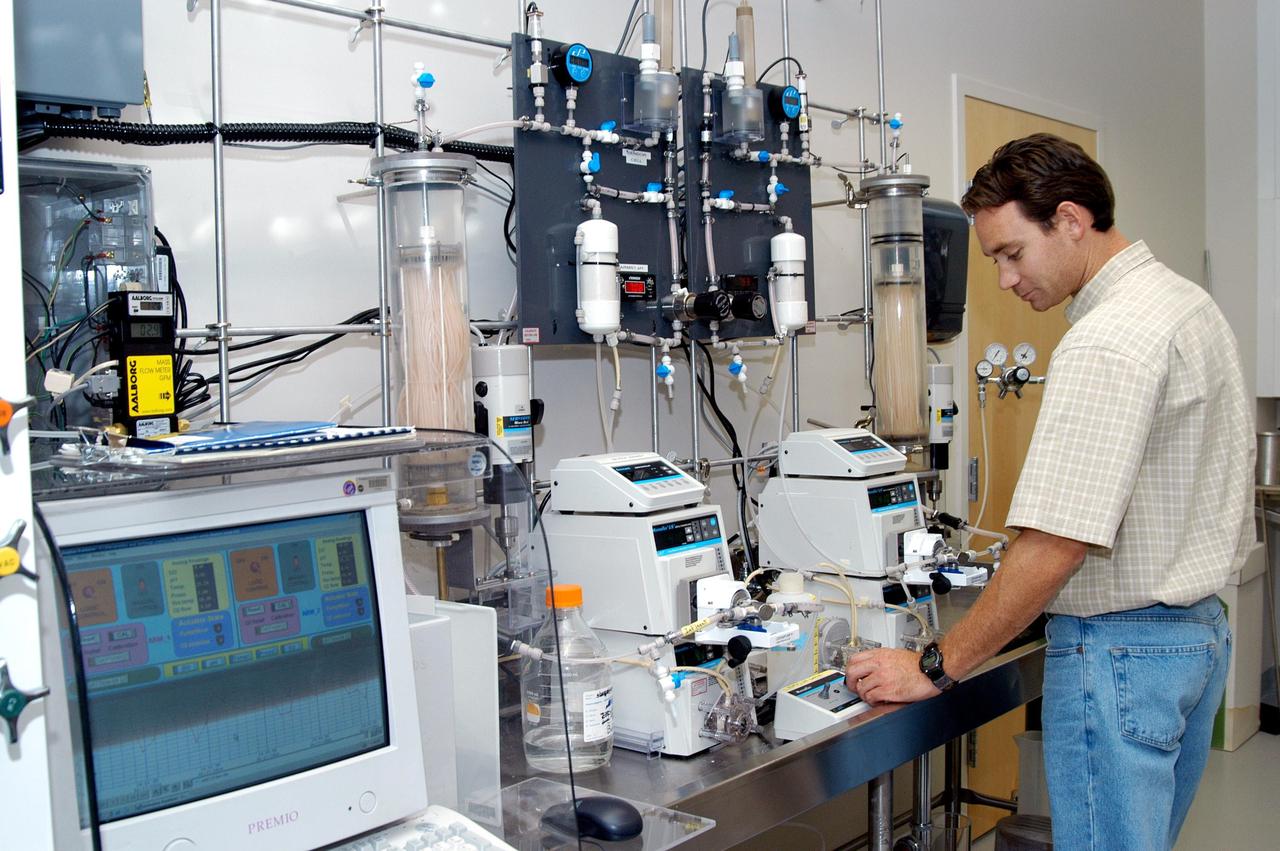 KENNEDY SPACE CENTER, FLA. - In the KSC Space Life Sciences Lab’s Resource Recovery lab, bioengineer Tony Rector checks the clear plexiglass ARMS reactor vessel. ARMS, or Aerobic Rotational Membrane System, is a wastewater processing project being tested for use on the International Space Station to collect, clean and reuse wastewater. It could be adapted for use on the Moon and Mars. The Lab is exploring various aspects of a bioregenerative life support system. Such research and technology development will be crucial to long-term habitation of space by humans.