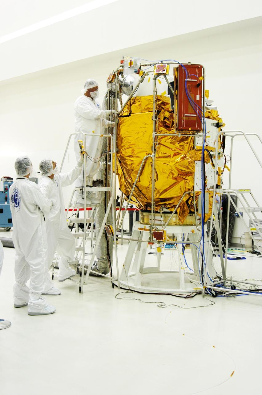 KENNEDY SPACE CENTER, FLA. - At Astrotech Space Operations in Titusville, Fla., workers place insulating blankets around the Mercury Surface, Space Environment, Geochemistry and Ranging (MESSENGER) spacecraft. Two solar arrays will be installed June 24-25, followed by a deployment test. The spacecraft will fly past Earth once, Venus twice and Mercury three times before starting a year-long orbital study of Mercury in March 2011. Launch is scheduled for July 30, 2004 from Pad 17-B at Cape Canaveral Air Force Station. MESSENGER was built for NASA by the Johns Hopkins University Applied Physics Laboratory in Laurel, Md.
