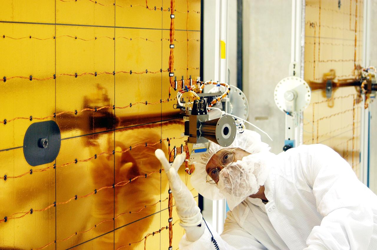 KENNEDY SPACE CENTER, FLA. - At Astrotech Space Operations in Titusville, Fla., a worker checks wiring on the Mercury Surface, Space Environment, Geochemistry and Ranging (MESSENGER) spacecraft. Two solar arrays will be installed June 24-25, followed by a deployment test. Launch is scheduled for July 30, 2004 from Pad 17-B at Cape Canaveral Air Force Station. The spacecraft will fly past Earth once, Venus twice and Mercury three times before starting a year-long orbital study of Mercury in March 2011. MESSENGER was built for NASA by the Johns Hopkins University Applied Physics Laboratory in Laurel, Md.