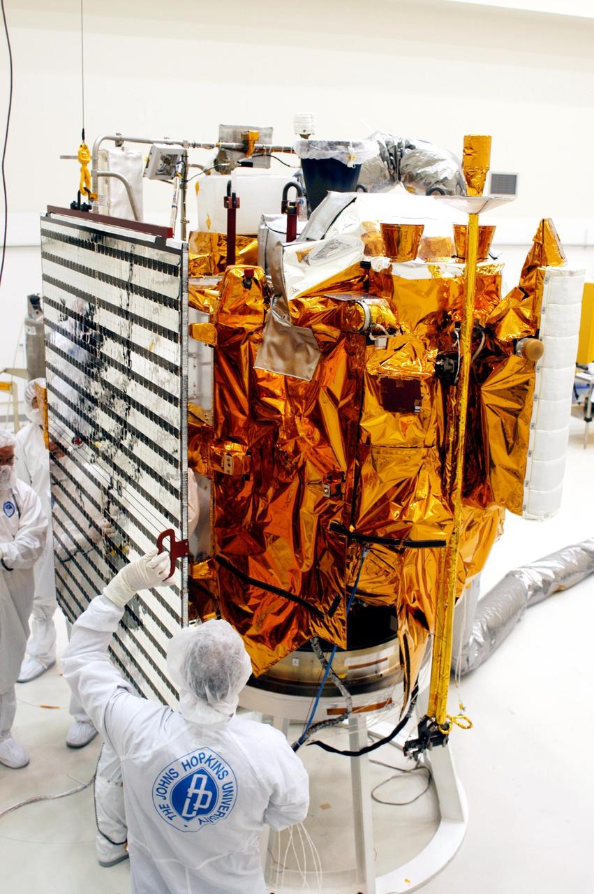 KENNEDY SPACE CENTER, FLA.  - Technicians at Astrotech in Titusville, Fla., maneuver a solar panel into place for installation on NASA’s MESSENGER spacecraft.  It is one of two large solar panels, supplemented with a nickel-hydrogen battery, that will provide MESSENGER’s power.  MESSENGER is scheduled to launch Aug. 2 aboard a Boeing Delta II rocket from Pad 17-B, Cape Canaveral Air Force Station, Fla. It will return to Earth for a gravity boost in July 2005, then fly past Venus twice, in October 2006 and June 2007. The spacecraft uses the tug of Venus’ gravity to resize and rotate its trajectory closer to Mercury’s orbit.  Three Mercury flybys, each followed about two months later by a course-correction maneuver, put MESSENGER in position to enter Mercury orbit in March 2011. During the flybys, MESSENGER will map nearly the entire planet in color, image most of the areas unseen by Mariner 10, and measure the composition of the surface, atmosphere and magnetosphere. It will be the first new data from Mercury in more than 30 years - and invaluable for planning MESSENGER’s year-long orbital mission.  MESSENGER was built for NASA by the Johns Hopkins University Applied Physics Laboratory in Laurel, Md.