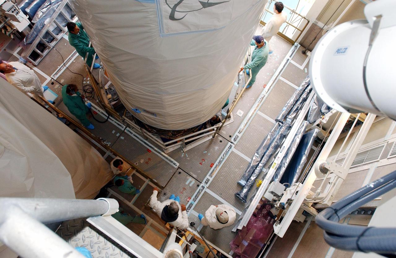 KENNEDY SPACE CENTER, FLA.  - Inside the mobile service tower, or gantry, at Space Launch Complex 2 on North Vandenberg Air Force Base, Calif., the Aura spacecraft is lowered toward the second stage of the Boeing Delta II rocket.  After it is mated with the second stage, the fairing will be installed.  The latest in the Earth Observing System (EOS) series, Aura is scheduled to launch July 10.  Aura’s four state-of-the-art instruments will study the dynamics of chemistry occurring in the atmosphere.  The spacecraft will provide data to help scientists better understand the Earth’s ozone, air quality and climate change.