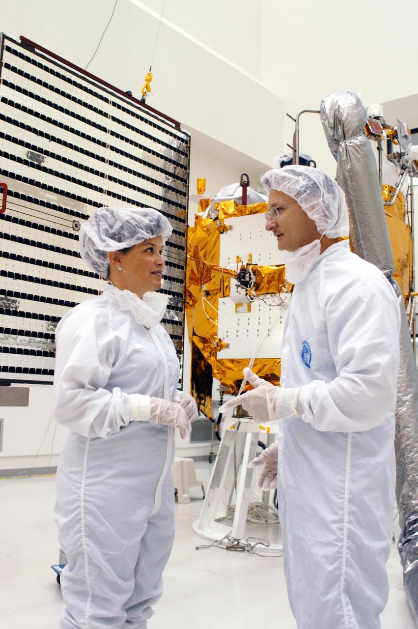 KENNEDY SPACE CENTER, FLA.  - At Astrotech in Titusville, Fla.,  NASA Mission Integration Manager Cheryle Mako and NASA Launch Site Integration Manager John Hueckel talk before the deployment of the solar array panels on the MESSENGER spacecraft behind them.  The solar arrays will provide MESSENGER’s power on its journey to Mercury.   MESSENGER is scheduled to launch Aug. 2 aboard a Boeing Delta II rocket from Pad 17-B, Cape Canaveral Air Force Station, Fla. It will return to Earth for a gravity boost in July 2005, then fly past Venus twice, in October 2006 and June 2007. The spacecraft uses the tug of Venus’ gravity to resize and rotate its trajectory closer to Mercury’s orbit.  Three Mercury flybys, each followed about two months later by a course-correction maneuver, put MESSENGER in position to enter Mercury orbit in March 2011. During the flybys, MESSENGER will map nearly the entire planet in color, image most of the areas unseen by Mariner 10, and measure the composition of the surface, atmosphere and magnetosphere. It will be the first new data from Mercury in more than 30 years - and invaluable for planning MESSENGER’s year-long orbital mission.  MESSENGER was built for NASA by the Johns Hopkins University Applied Physics Laboratory in Laurel, Md.