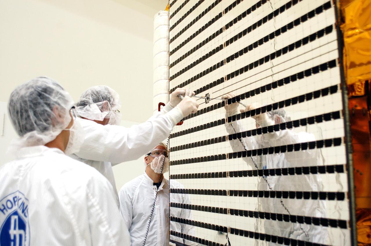 KENNEDY SPACE CENTER, FLA. - At Astrotech in Titusville, Fla., technicians with The Johns Hopkins University Applied Physics Laboratory (APL) prepare one of two solar array panels on the MESSENGER spacecraft for deployment. The panels will provide MESSENGER’s power on its journey to Mercury. MESSENGER is scheduled to launch Aug. 2 aboard a Boeing Delta II rocket from Pad 17-B, Cape Canaveral Air Force Station, Fla. It will return to Earth for a gravity boost in July 2005, then fly past Venus twice, in October 2006 and June 2007. The spacecraft uses the tug of Venus’ gravity to resize and rotate its trajectory closer to Mercury’s orbit. Three Mercury flybys, each followed about two months later by a course-correction maneuver, put MESSENGER in position to enter Mercury orbit in March 2011. During the flybys, MESSENGER will map nearly the entire planet in color, image most of the areas unseen by Mariner 10, and measure the composition of the surface, atmosphere and magnetosphere. It will be the first new data from Mercury in more than 30 years - and invaluable for planning MESSENGER’s year-long orbital mission. MESSENGER was built for NASA by APL in Laurel, Md.