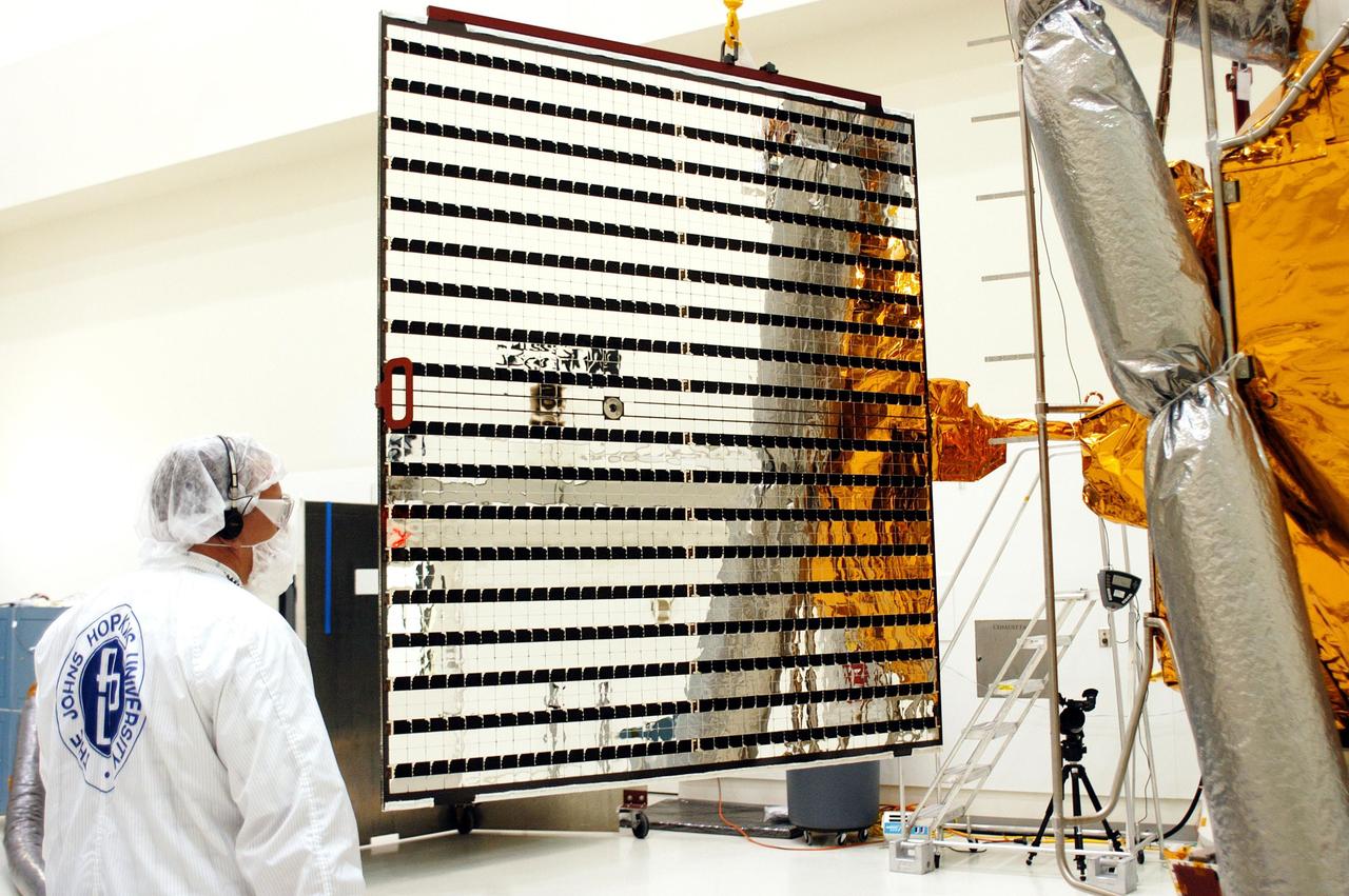 KENNEDY SPACE CENTER, FLA.  - At Astrotech in Titusville, Fla., a technician with The Johns Hopkins University Applied Physics Laboratory (APL)  watches as one of the solar array panels on the MESSENGER spacecraft is deployed.  The two panels will provide MESSENGER’s power on its journey to Mercury.   MESSENGER is scheduled to launch Aug. 2 aboard a Boeing Delta II rocket from Pad 17-B, Cape Canaveral Air Force Station, Fla. It will return to Earth for a gravity boost in July 2005, then fly past Venus twice, in October 2006 and June 2007. The spacecraft uses the tug of Venus’ gravity to resize and rotate its trajectory closer to Mercury’s orbit.  Three Mercury flybys, each followed about two months later by a course-correction maneuver, put MESSENGER in position to enter Mercury orbit in March 2011. During the flybys, MESSENGER will map nearly the entire planet in color, image most of the areas unseen by Mariner 10, and measure the composition of the surface, atmosphere and magnetosphere. It will be the first new data from Mercury in more than 30 years - and invaluable for planning MESSENGER’s year-long orbital mission.  MESSENGER was built for NASA by APL in Laurel, Md.