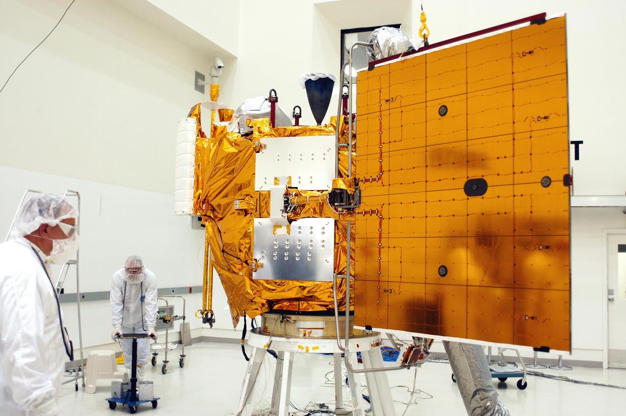 KENNEDY SPACE CENTER, FLA.  - At Astrotech in Titusville, Fla., technicians with The Johns Hopkins University Applied Physics Laboratory (APL) monitor the progress of the solar array deployment on the MESSENGER spacecraft.  The two panels will provide MESSENGER’s power on its journey to Mercury.   MESSENGER is scheduled to launch Aug. 2 aboard a Boeing Delta II rocket from Pad 17-B, Cape Canaveral Air Force Station, Fla. It will return to Earth for a gravity boost in July 2005, then fly past Venus twice, in October 2006 and June 2007. The spacecraft uses the tug of Venus’ gravity to resize and rotate its trajectory closer to Mercury’s orbit.  Three Mercury flybys, each followed about two months later by a course-correction maneuver, put MESSENGER in position to enter Mercury orbit in March 2011. During the flybys, MESSENGER will map nearly the entire planet in color, image most of the areas unseen by Mariner 10, and measure the composition of the surface, atmosphere and magnetosphere. It will be the first new data from Mercury in more than 30 years - and invaluable for planning MESSENGER’s year-long orbital mission.  MESSENGER was built for NASA by APL in Laurel, Md.