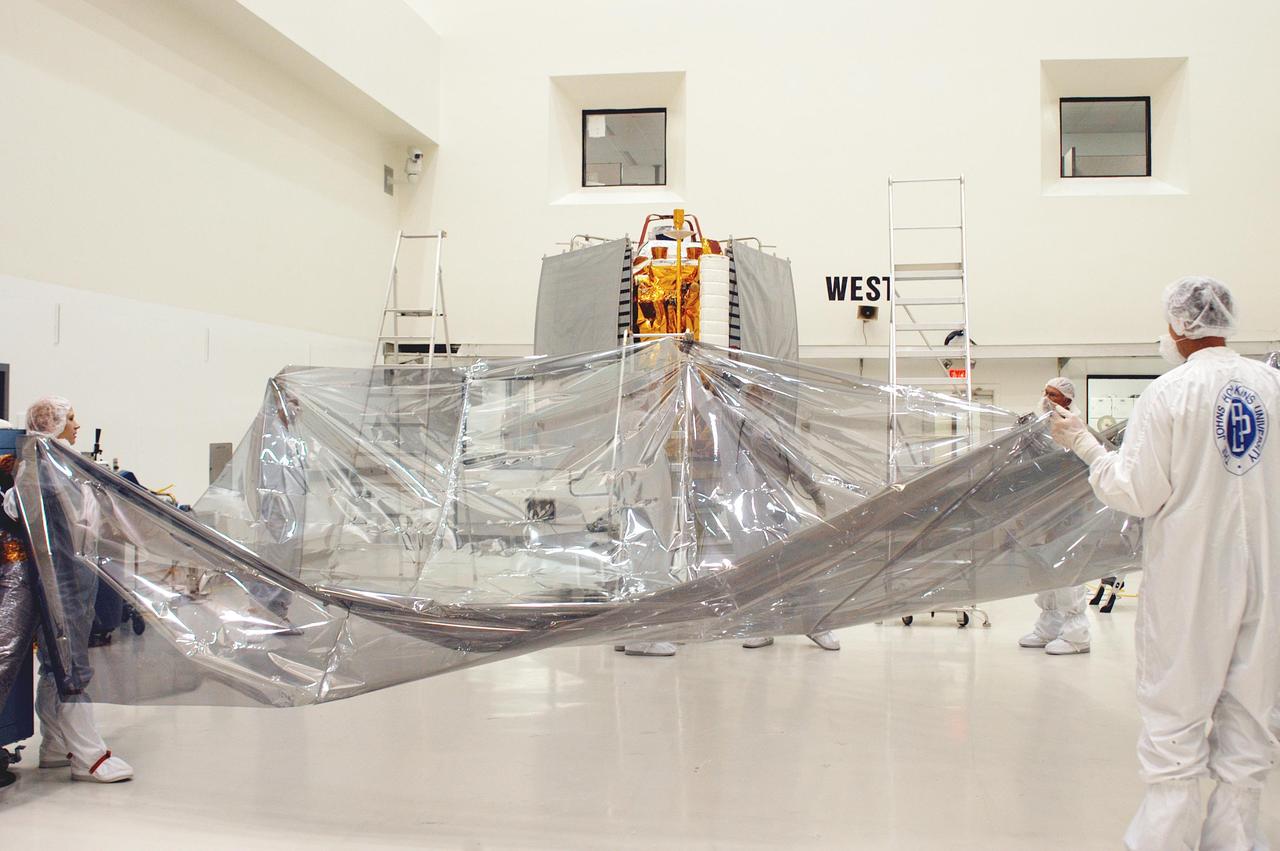 KENNEDY SPACE CENTER, FLA.  - At Astrotech in Titusville, Fla., technicians with The Johns Hopkins University Applied Physics Laboratory (APL) prepare to cover the MESSESNGER spacecraft for a move to a hazardous processing facility in preparation for loading the spacecraft’s complement of hypergolic propellants.   MESSENGER is scheduled to launch Aug. 2 aboard a Boeing Delta II rocket from Pad 17-B, Cape Canaveral Air Force Station, Fla., on a journey to Mercury.  It will return to Earth for a gravity boost in July 2005, then fly past Venus twice, in October 2006 and June 2007. The spacecraft uses the tug of Venus’ gravity to resize and rotate its trajectory closer to Mercury’s orbit.  Three Mercury flybys, each followed about two months later by a course-correction maneuver, put MESSENGER in position to enter Mercury orbit in March 2011. During the flybys, MESSENGER will map nearly the entire planet in color, image most of the areas unseen by Mariner 10, and measure the composition of the surface, atmosphere and magnetosphere. It will be the first new data from Mercury in more than 30 years - and invaluable for planning MESSENGER’s year-long orbital mission.  MESSENGER was built for NASA by APL in Laurel, Md.