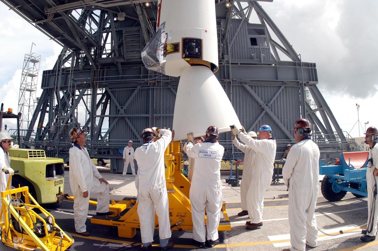 KENNEDY SPACE CENTER, FLA. -  On Pad 17-B, Cape Canaveral Air Force Station, workers steady the Solid Rocket Booster (SRB) waiting to be lifted up the mobile service tower. The SRB and eight others will be mated to the Boeing Delta II Heavy rocket for the Aug. 2 launch of the MESSENGER spacecraft to the planet Mercury.  The spacecraft is expected to reach orbit around Mercury in March 2011.  MESSENGER was built for NASA by the Johns Hopkins University Applied Physics Laboratory in Laurel, Md.