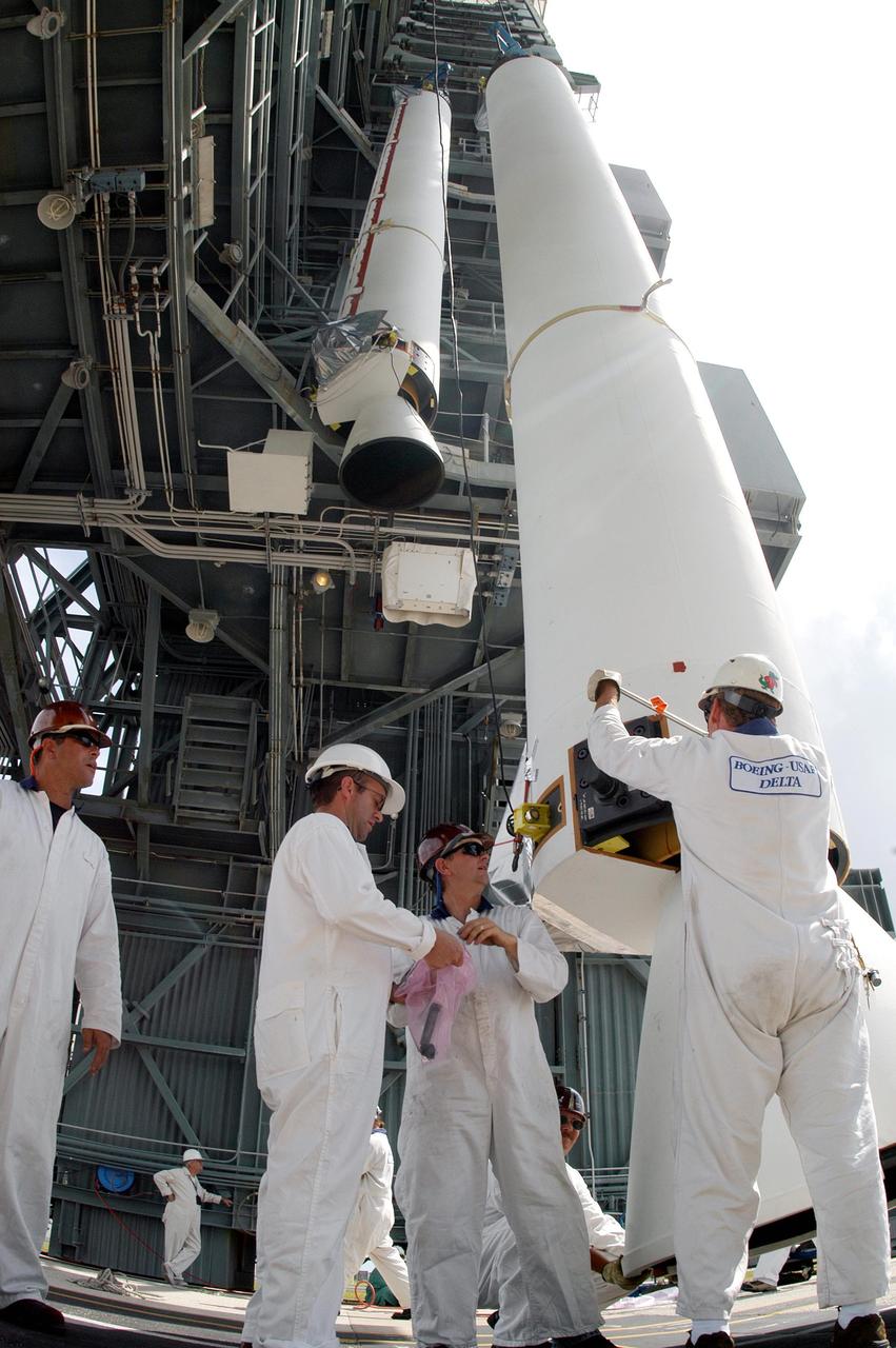 KENNEDY SPACE CENTER, FLA. -  On Pad 17-B, Cape Canaveral Air Force Station, workers check the Solid Rocket Booster (SRB) waiting to be lifted up the mobile service tower. The SRB and eight others will be mated to the Boeing Delta II Heavy rocket for the Aug. 2 launch of the MESSENGER spacecraft to the planet Mercury.  The spacecraft is expected to reach orbit around Mercury in March 2011.  MESSENGER was built for NASA by the Johns Hopkins University Applied Physics Laboratory in Laurel, Md.